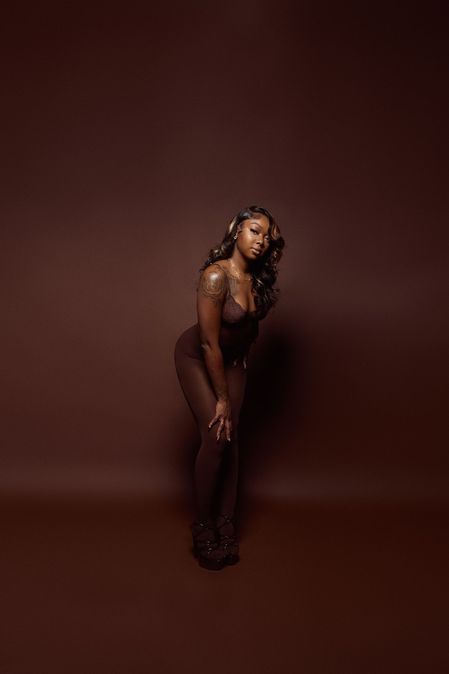 Dramatic silhouette poses against deep brown background in artistic photo sequence.