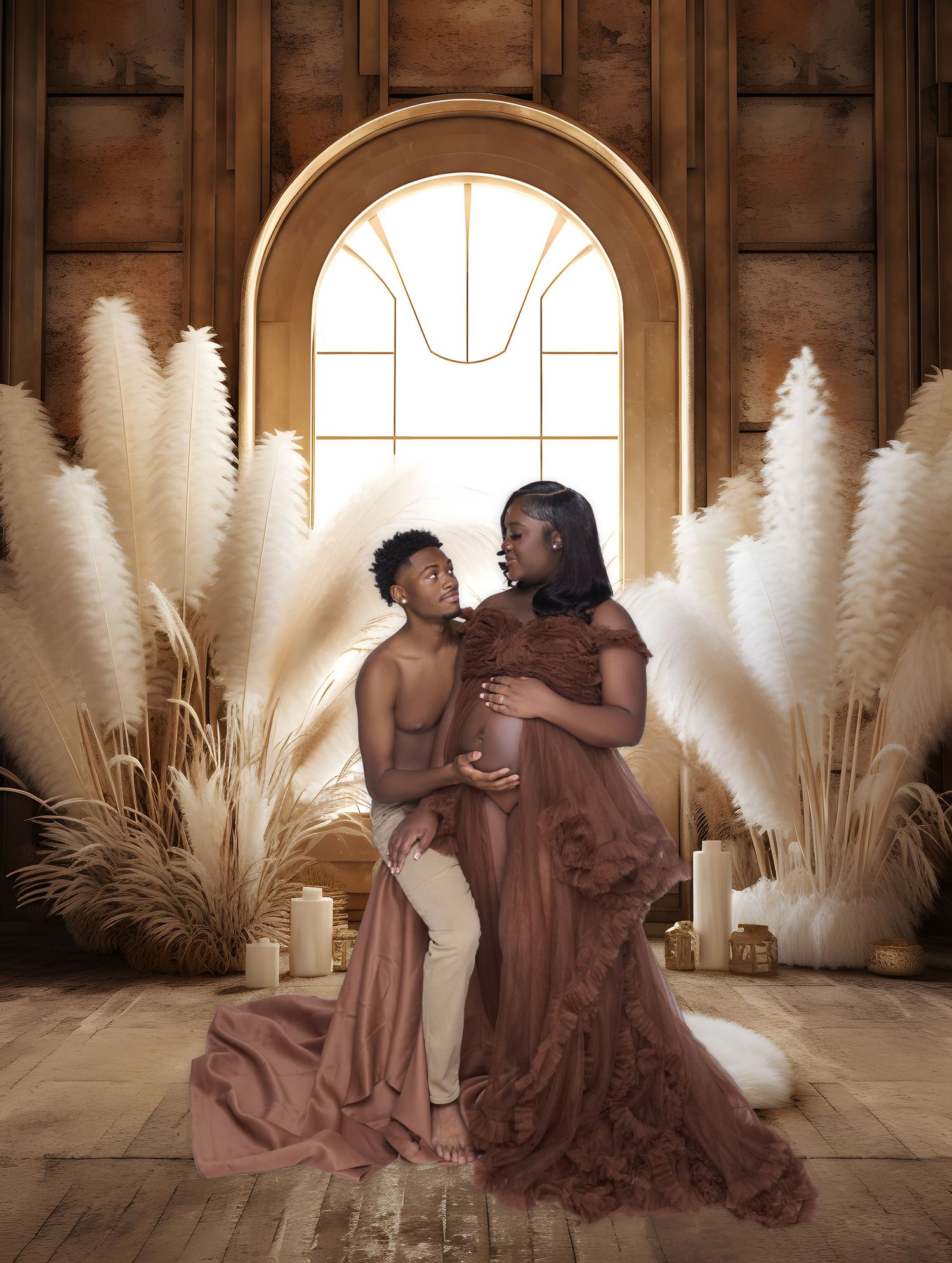 Romantic maternity photoshoot featuring flowing pampas grass and soft brown dresses in an elegant indoor setting.