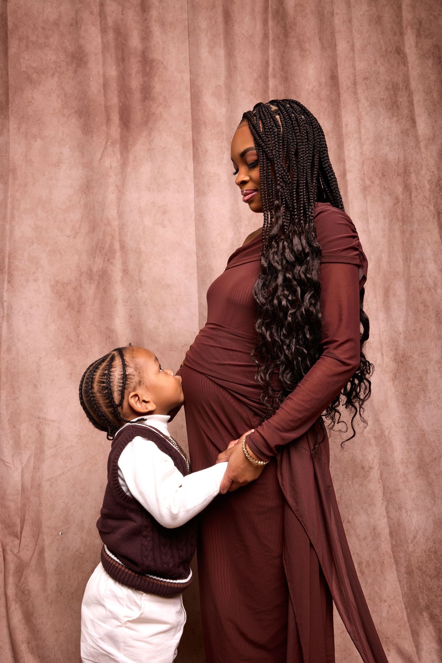 Tender family moments captured in sequence against pink studio backdrop.