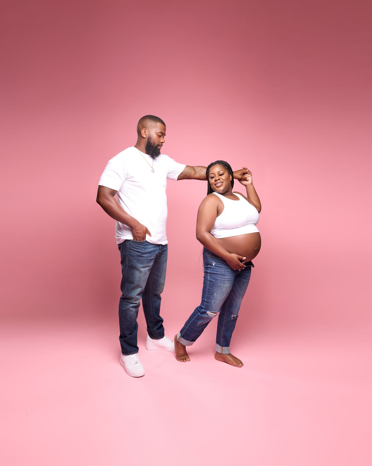 Playful maternity photoshoot sequence against pink background with casual denim and white attire.