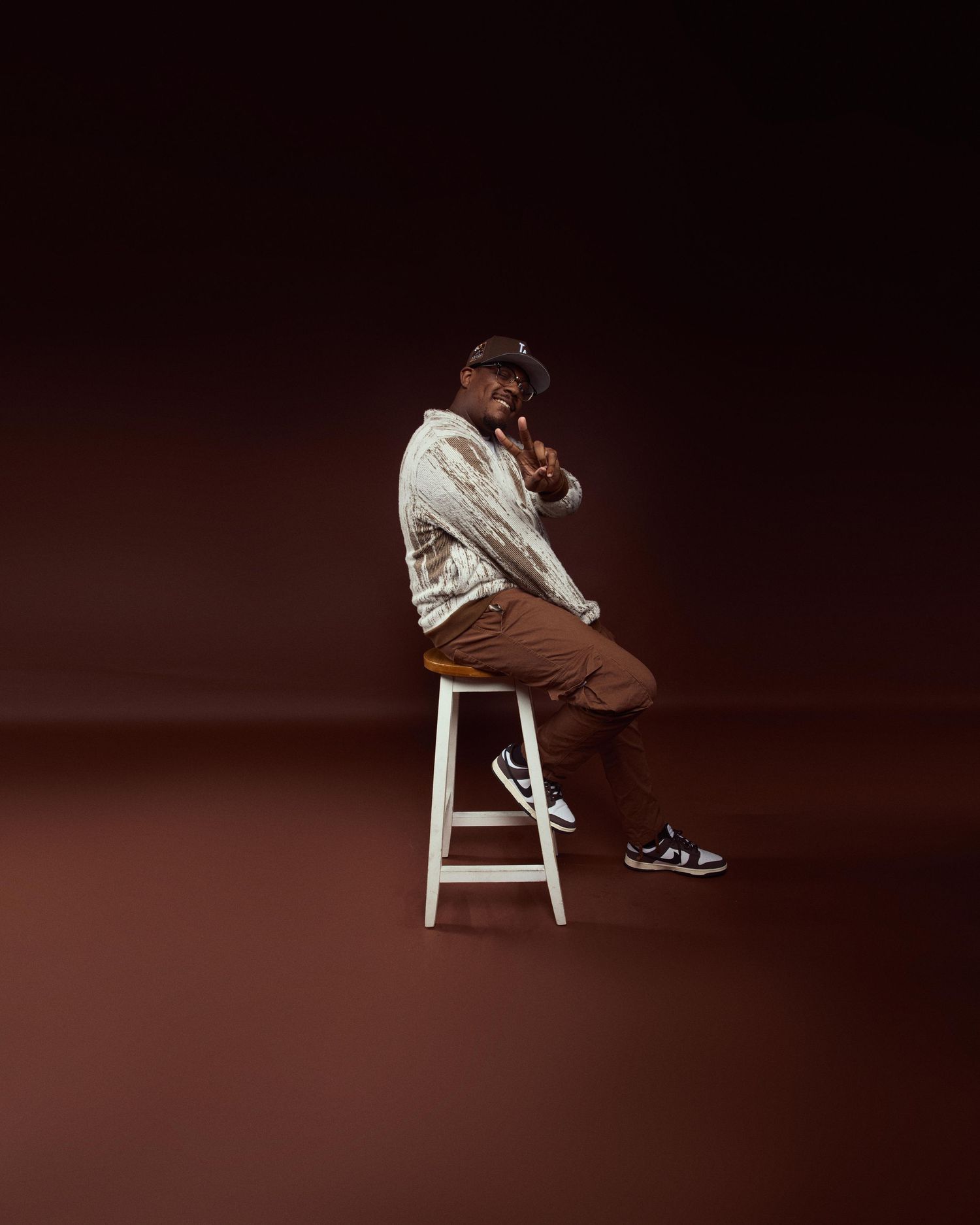 Artistic portrait series featuring minimalist composition with white stool against dark background.