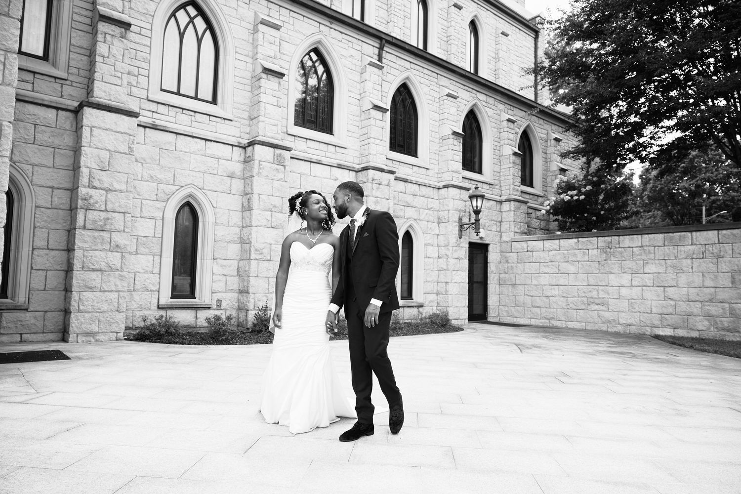 Black and white graduation photos outside historic stone building.