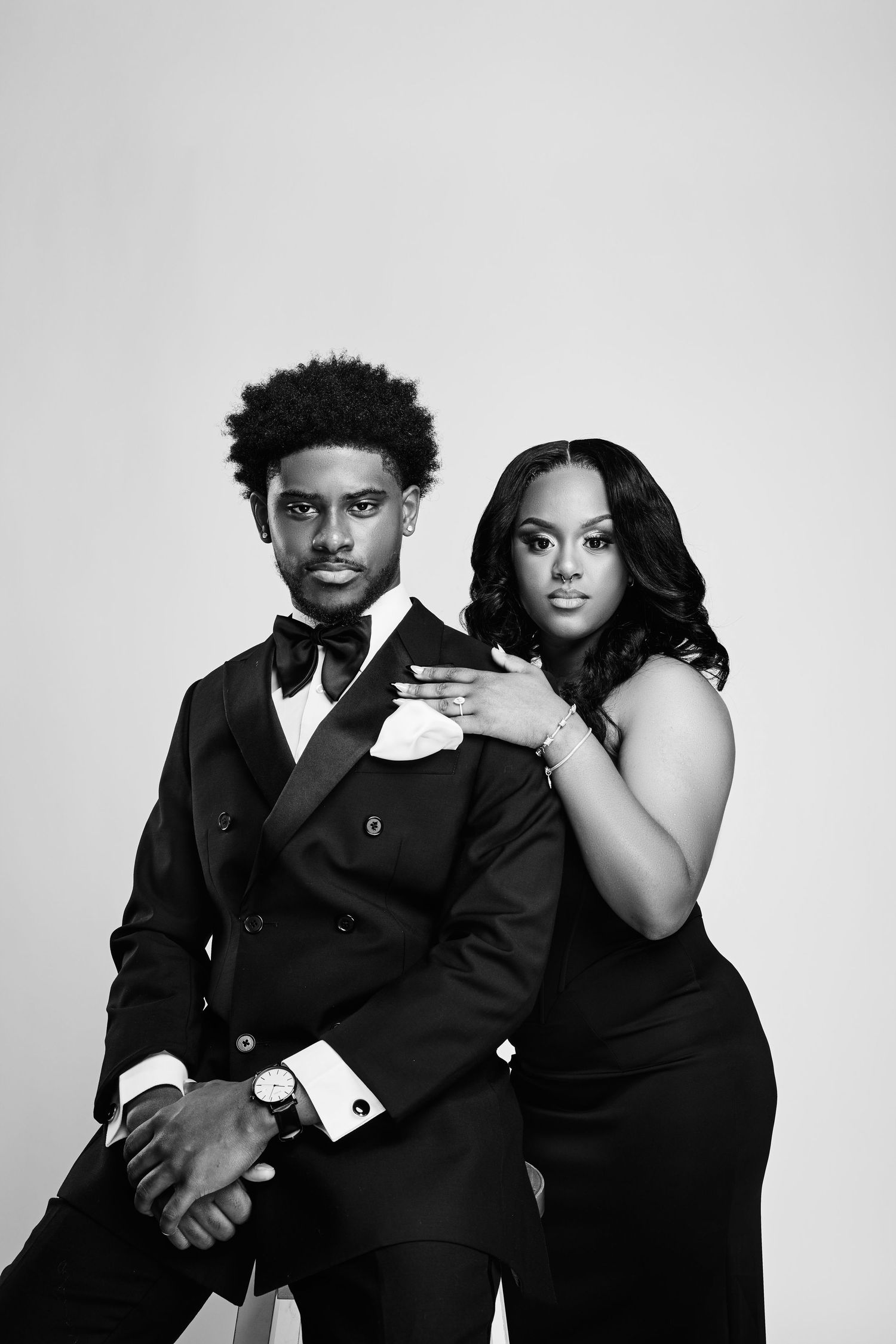 Couple in black formal wear poses together in series of intimate black and white portraits.