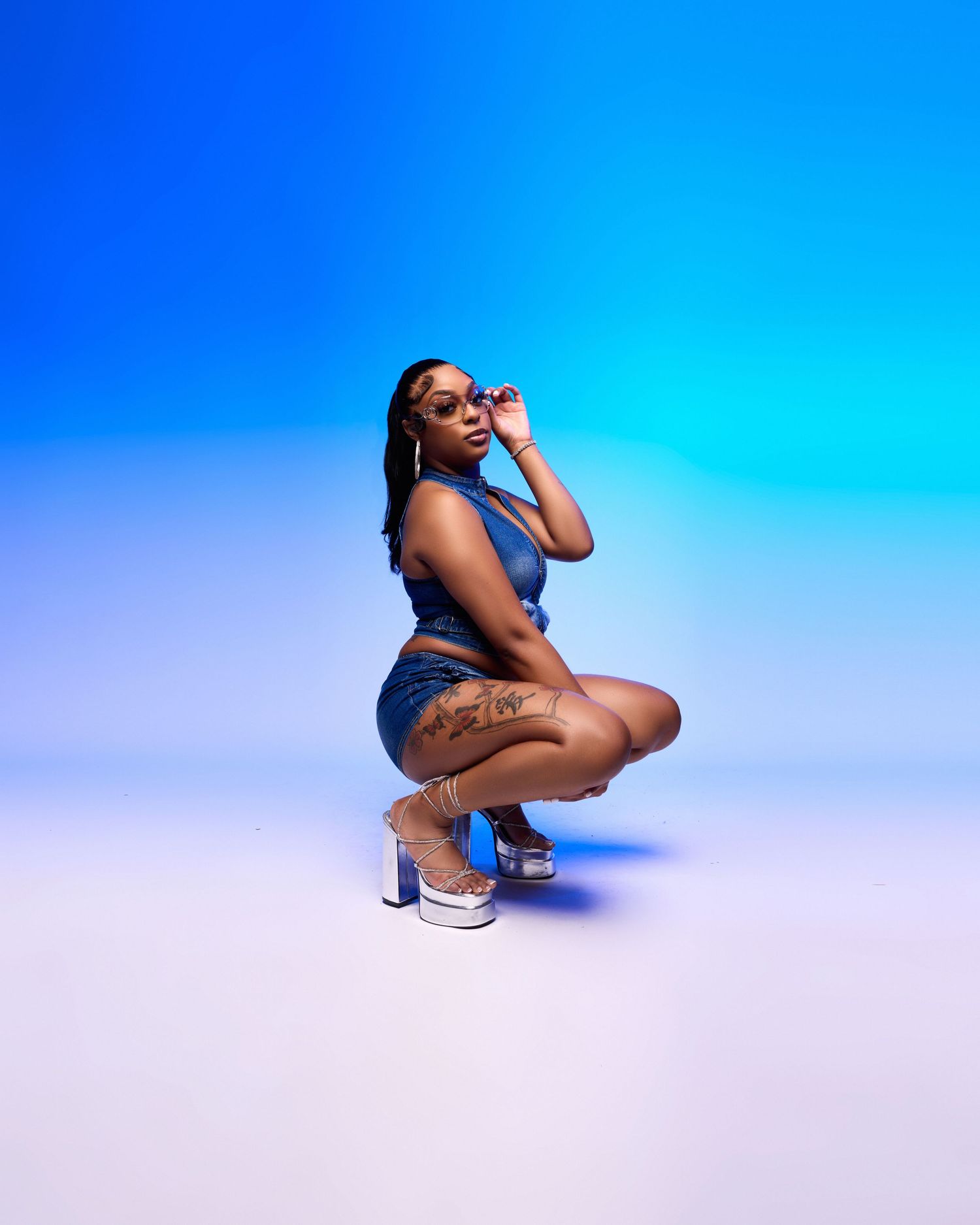 Fashion shoot with blue gradient background showing dynamic poses in urban style.