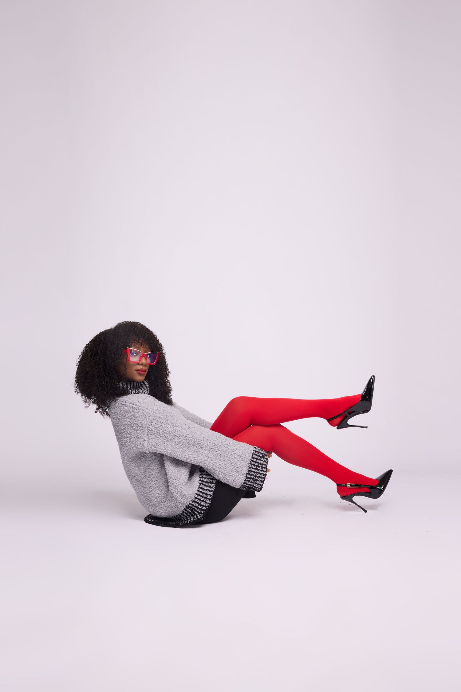 Fashion model poses in grey sweater and red boots against white background in artistic sequence.