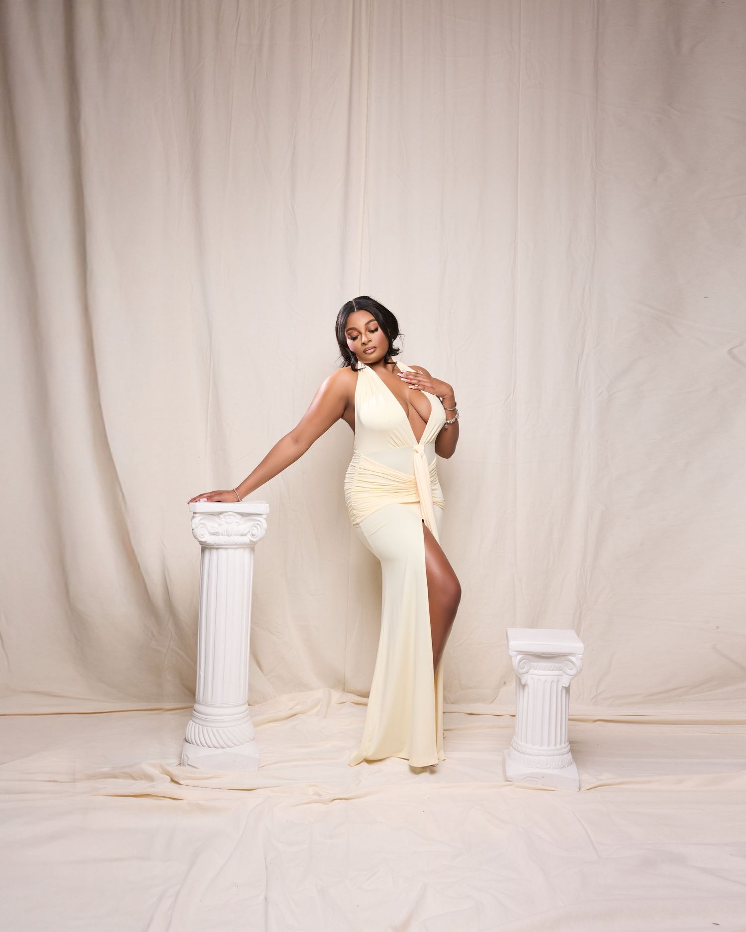 Elegant portrait series with classical white columns and flowing fabric against neutral backdrop.
