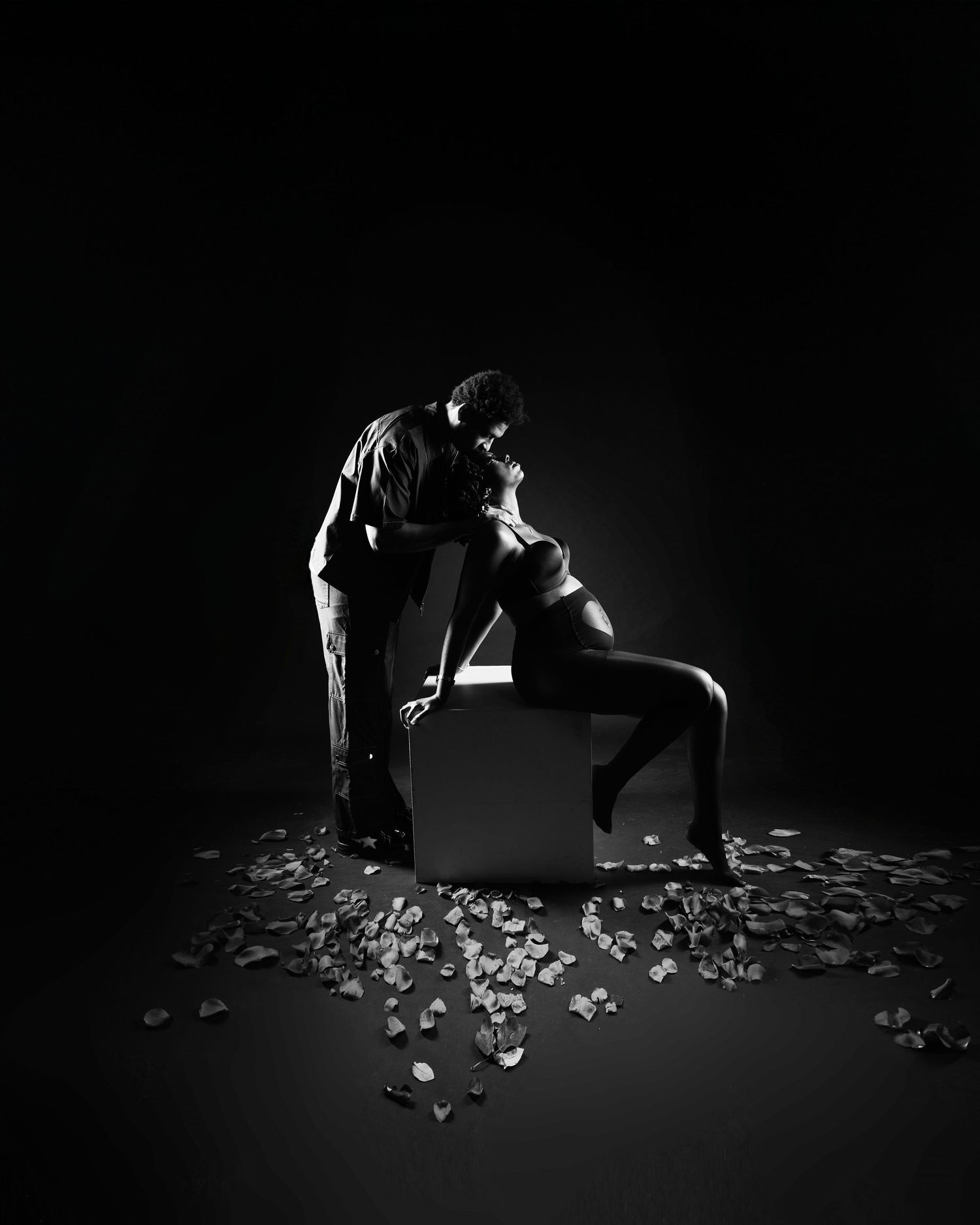 Artistic black and white photo series with dramatic lighting and scattered rose petals on floor.