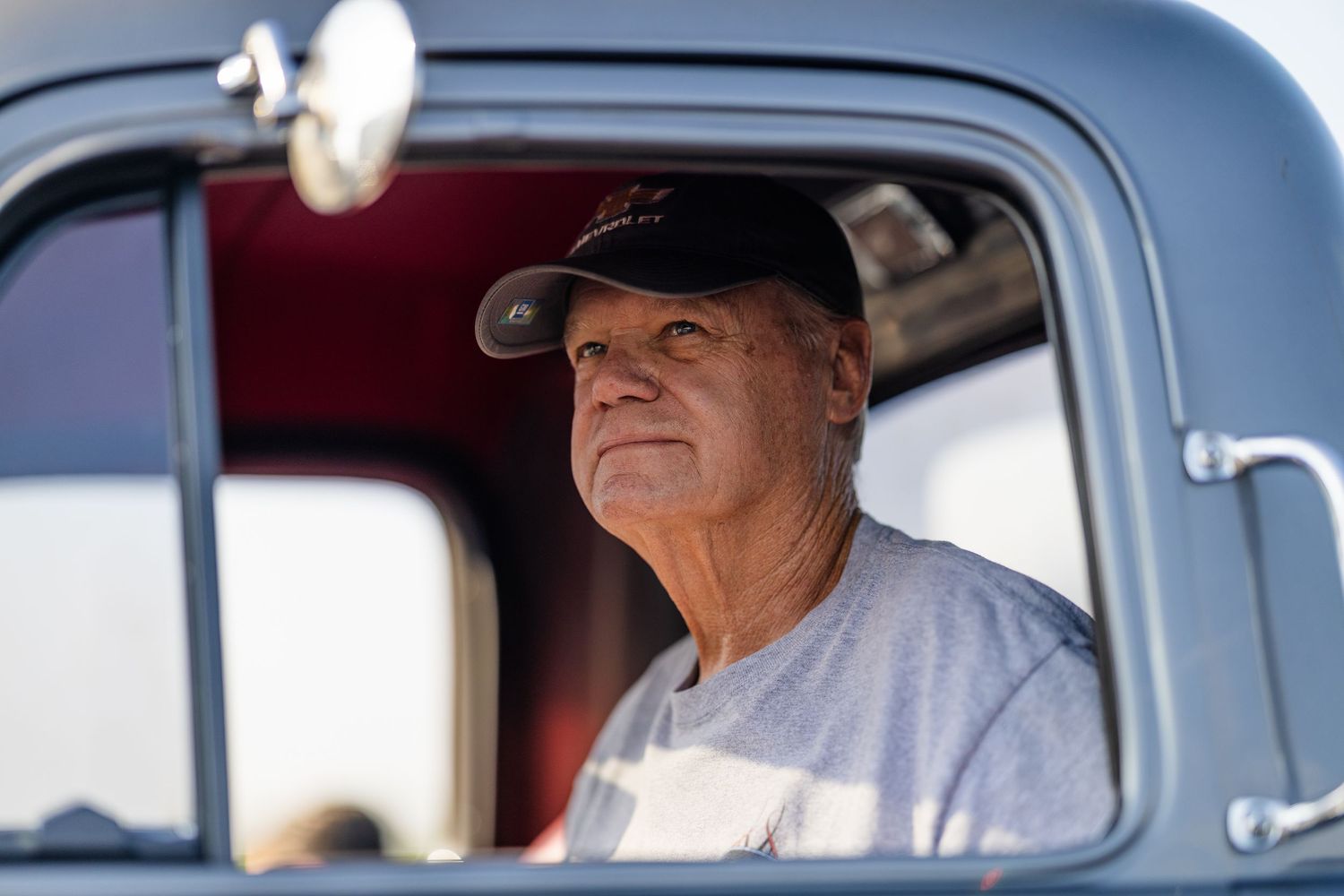View through vintage car windows at outdoor auto show.