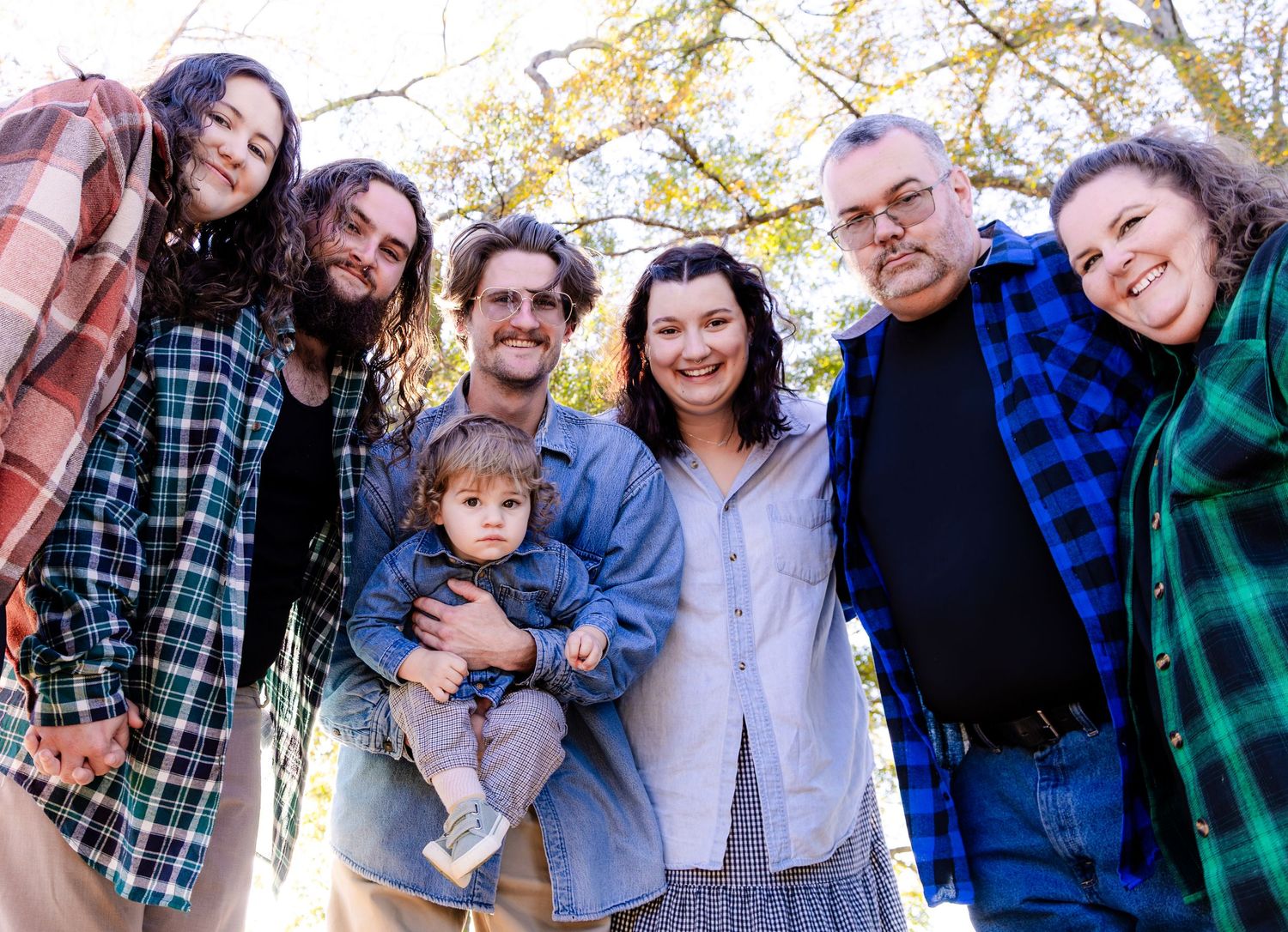 A series of candid outdoor family photos showing joyful moments and embraces against natural backgrounds.
