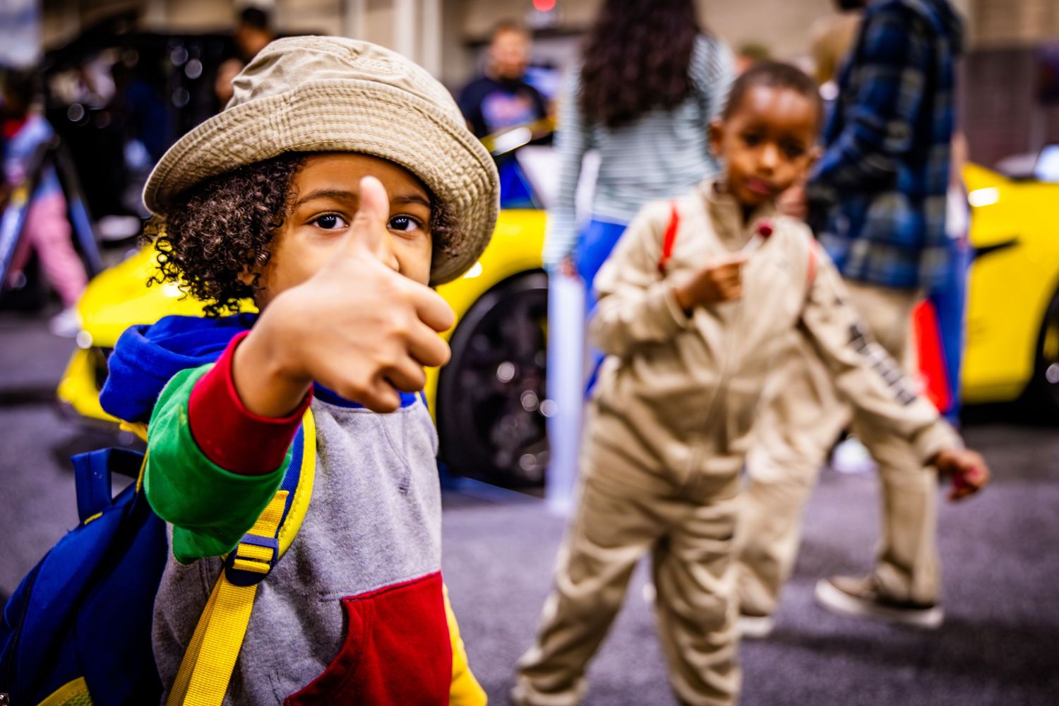 Children playing with toys at an indoor event with yellow walls in the background.