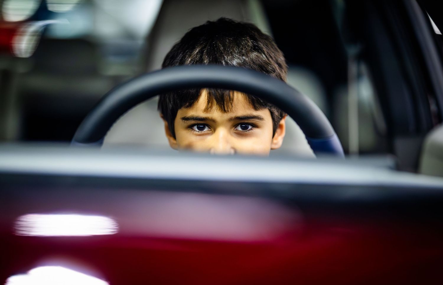View through a car windshield showing reflections and interior details.