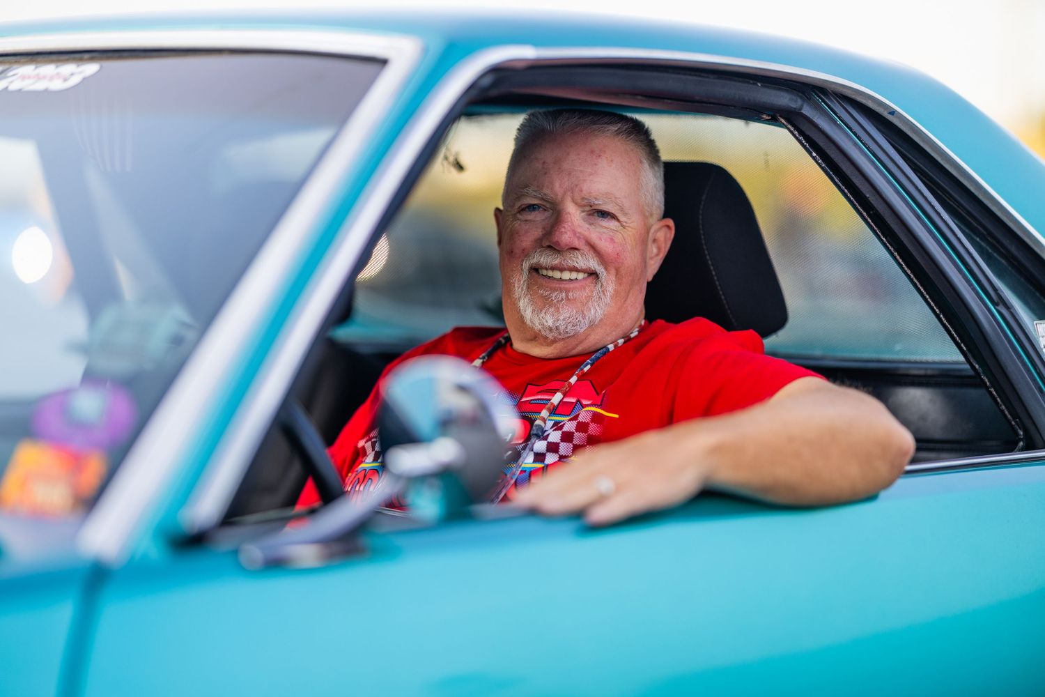 Classic car enthusiasts enjoying a vintage automobile show with bright blue vehicles.