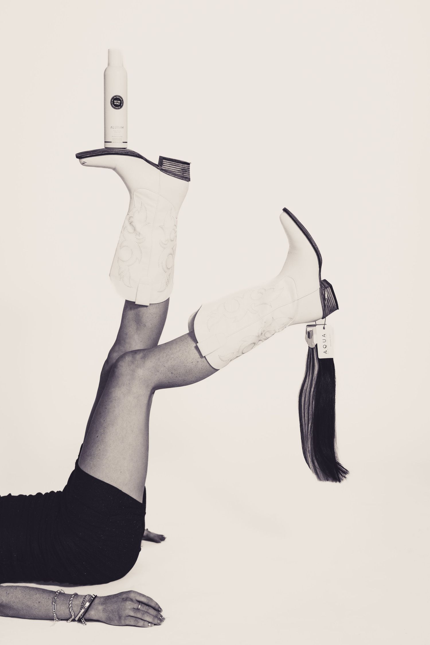 Artistic photo of white boots with styling tools against light background.