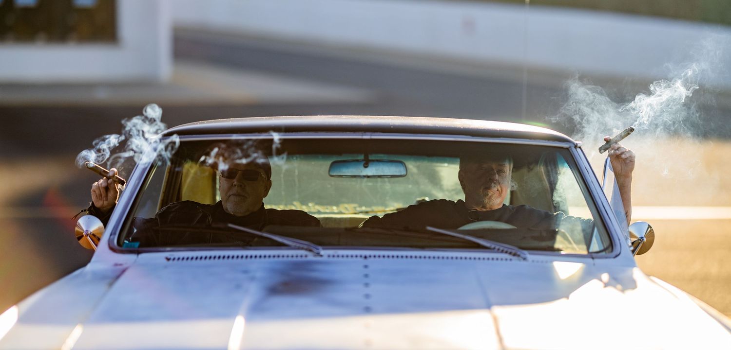 A vintage white car decorated with ornate silver details on its windshield.