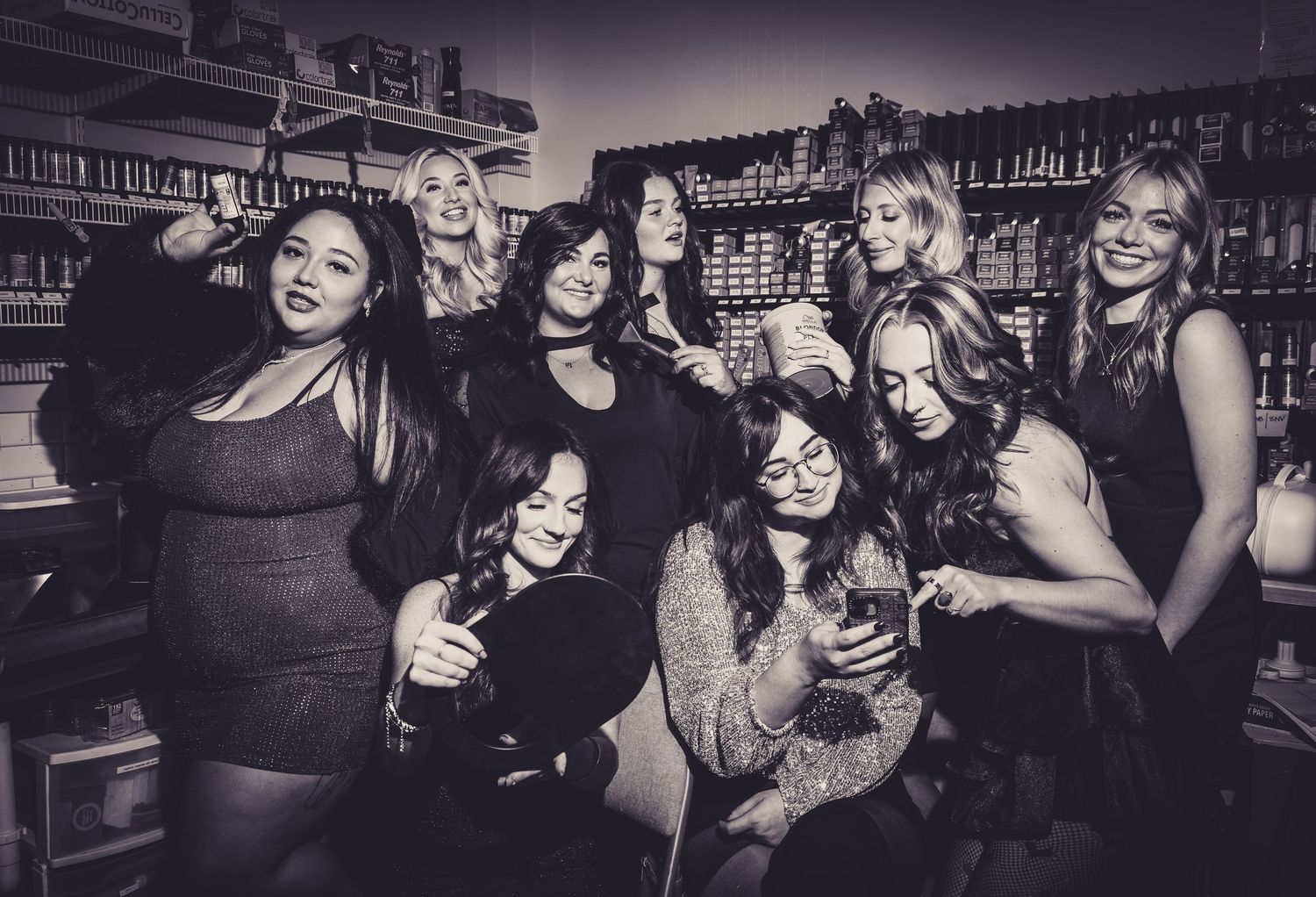 A group of friends laughing and celebrating together at a bar in black and white.