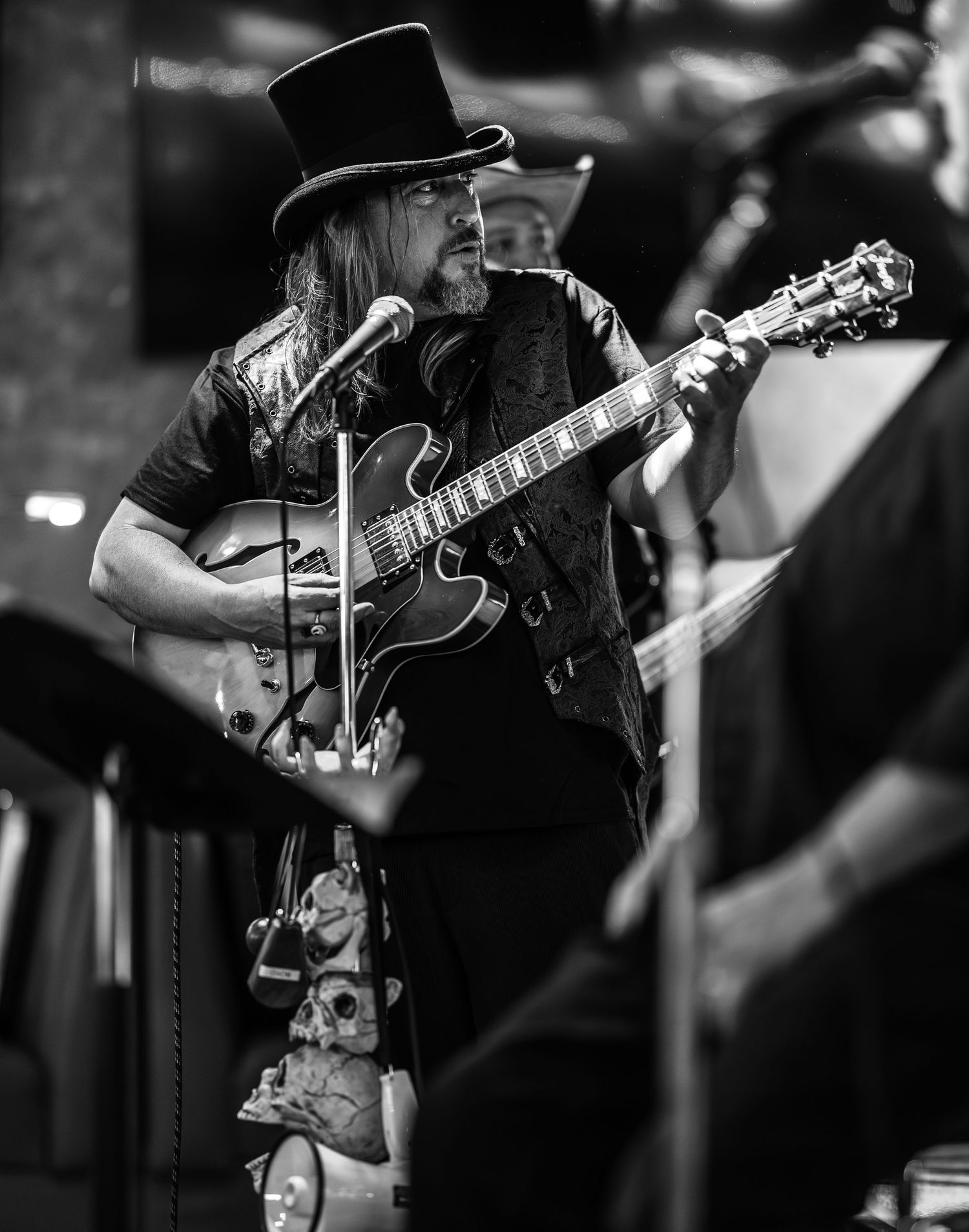 Musicians performing on stage in black and white photography.