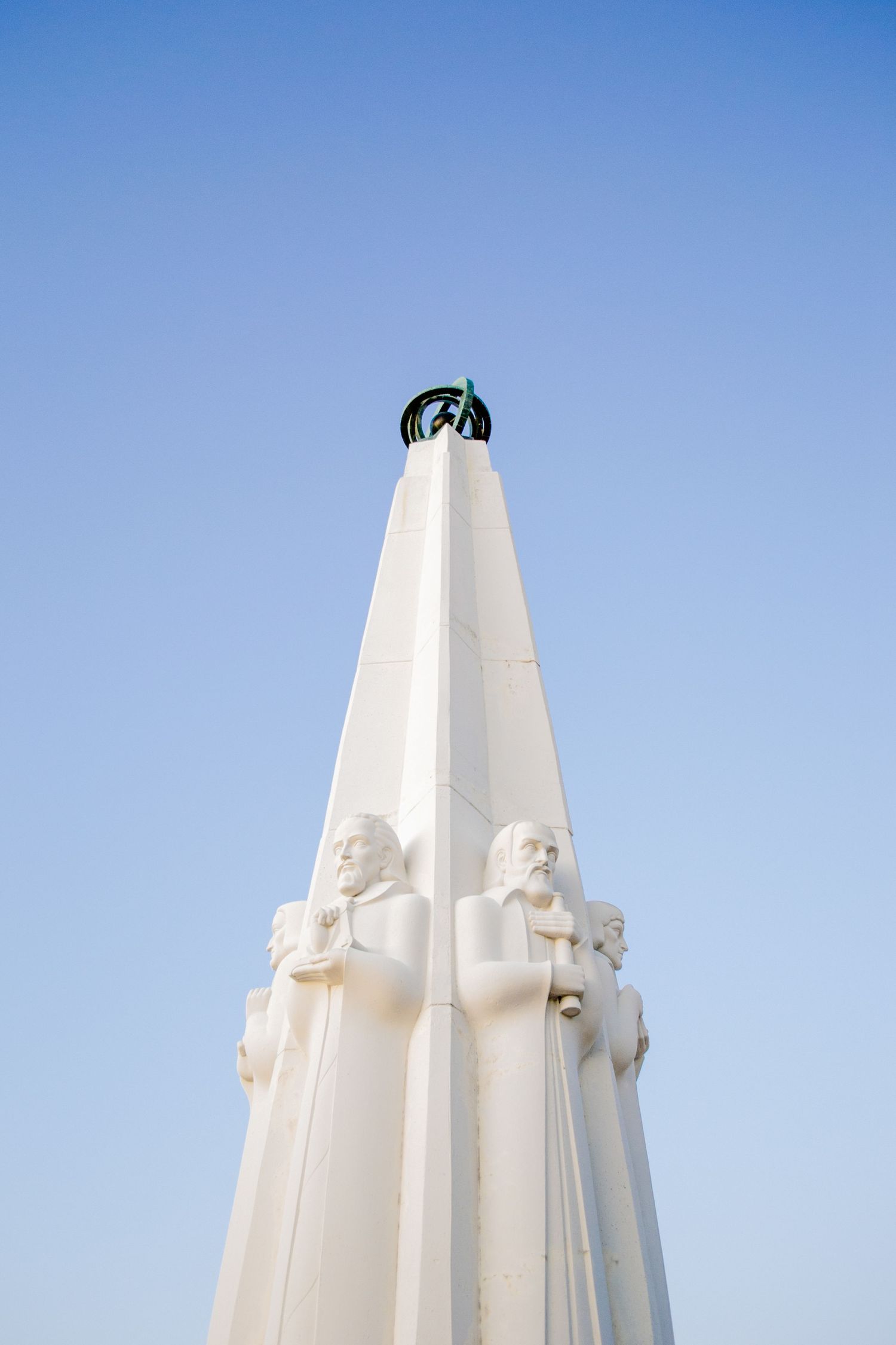 Photo of a monument against the blue sky outside the Griffith Observatory in Los Angeles.
