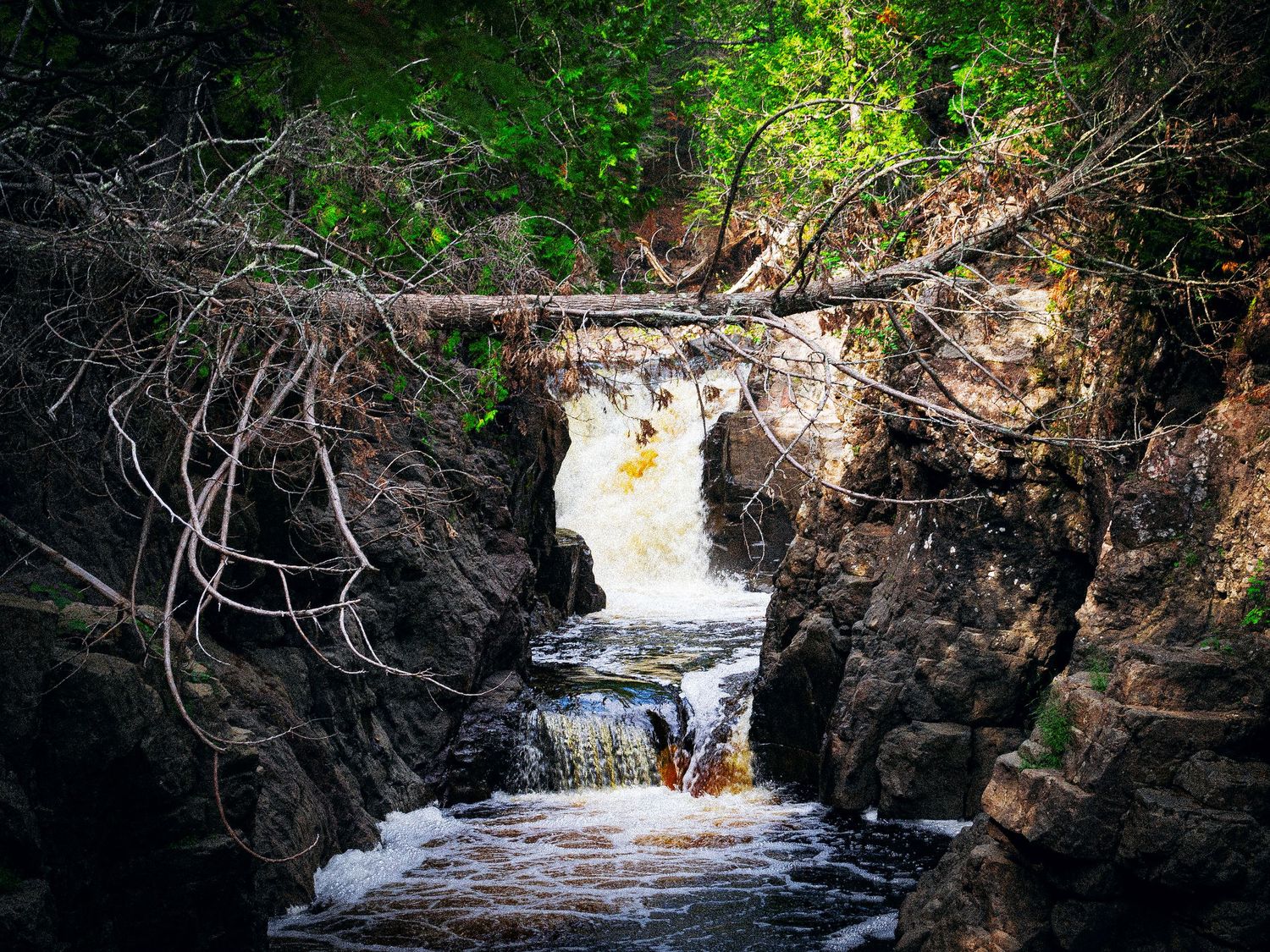 Photo of a waterfall surrounded by rock.