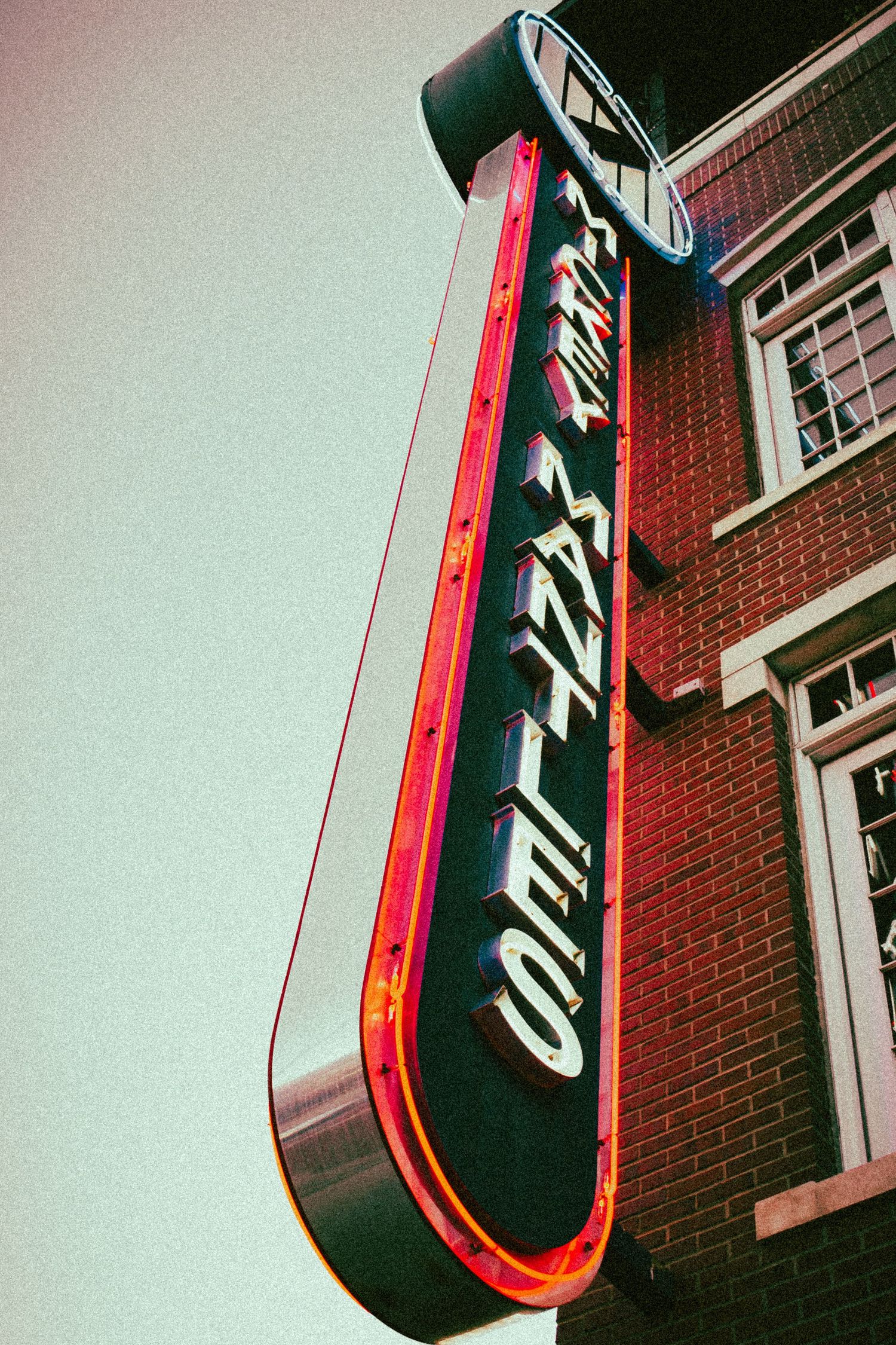 Dramatic angle of a neon sign with a vintage film effect.
