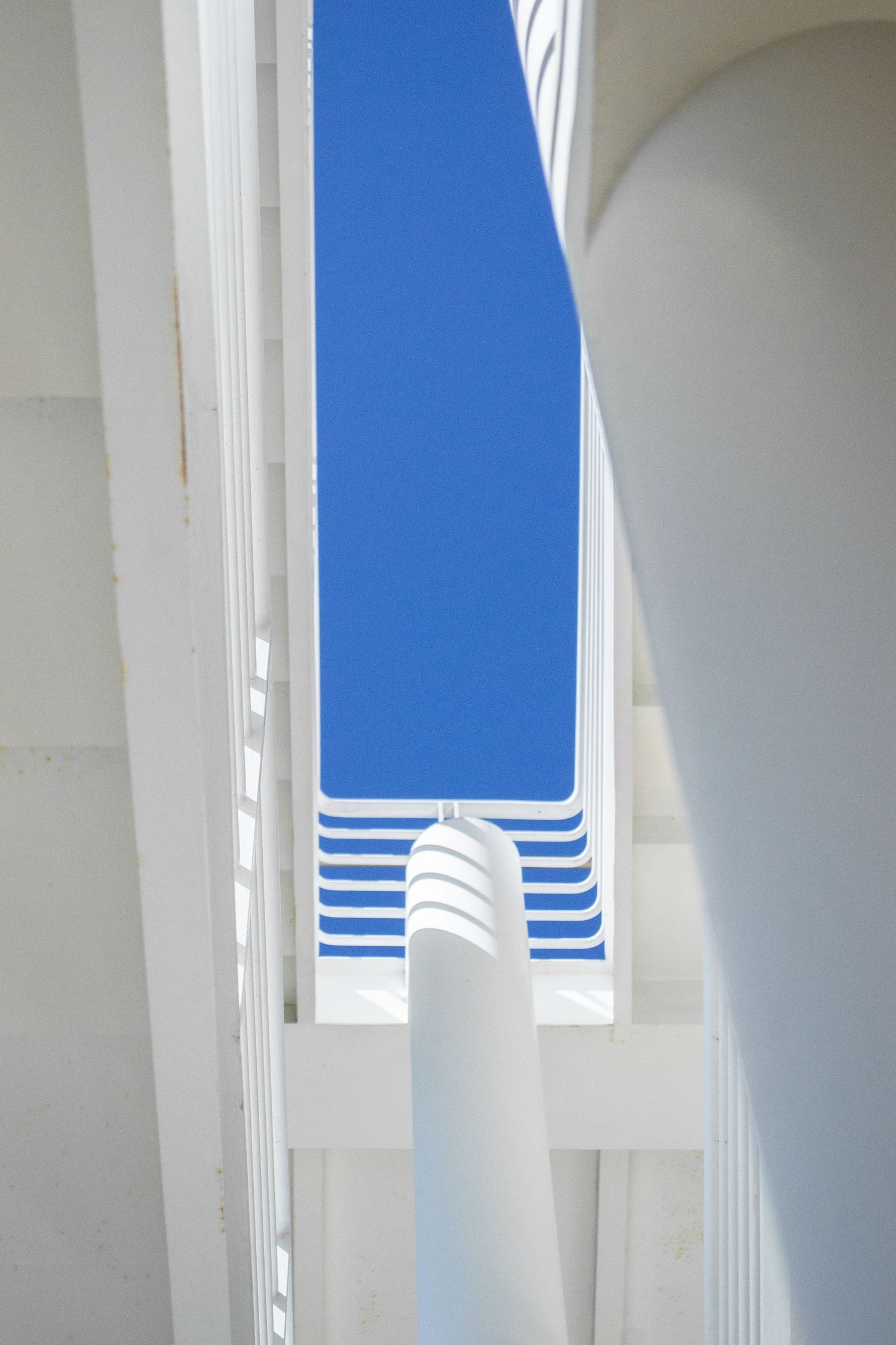 Abstract photo of a white staircase with a strip of blue sky.