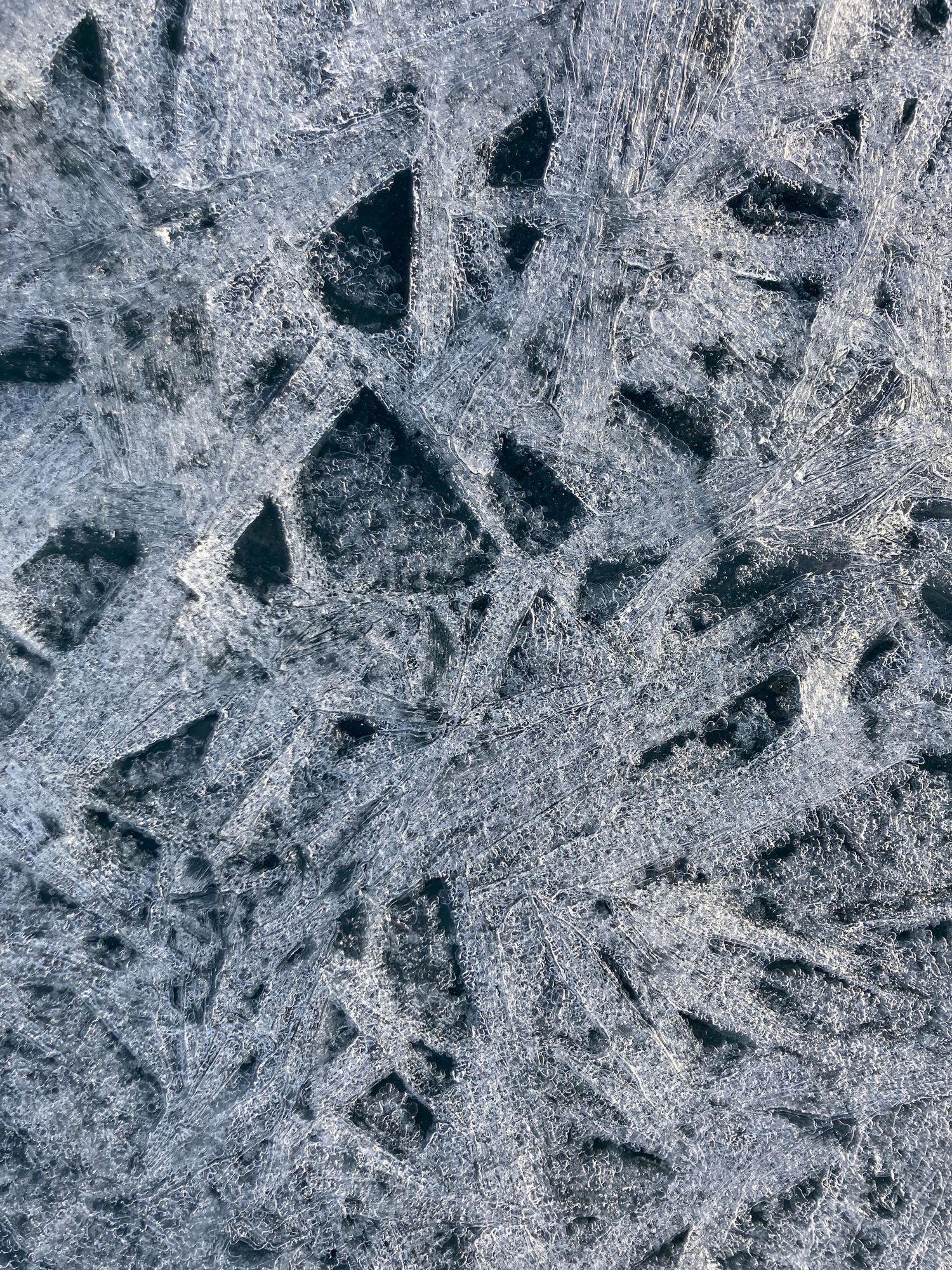 Top-down picture of ice frozen over a lake.