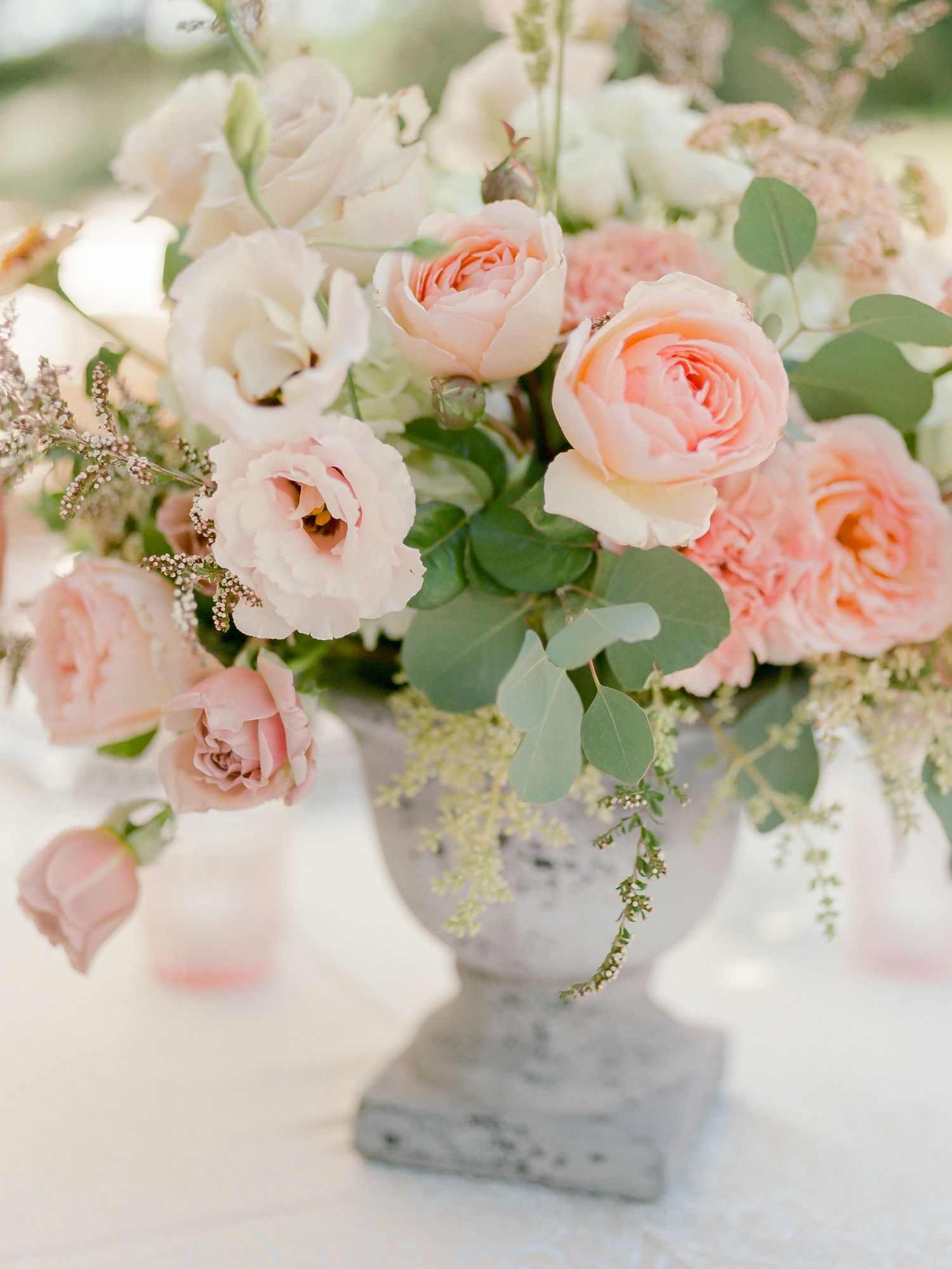 Elegant floral arrangement of blush pink roses and eucalyptus in a gray stone vase in Napa.