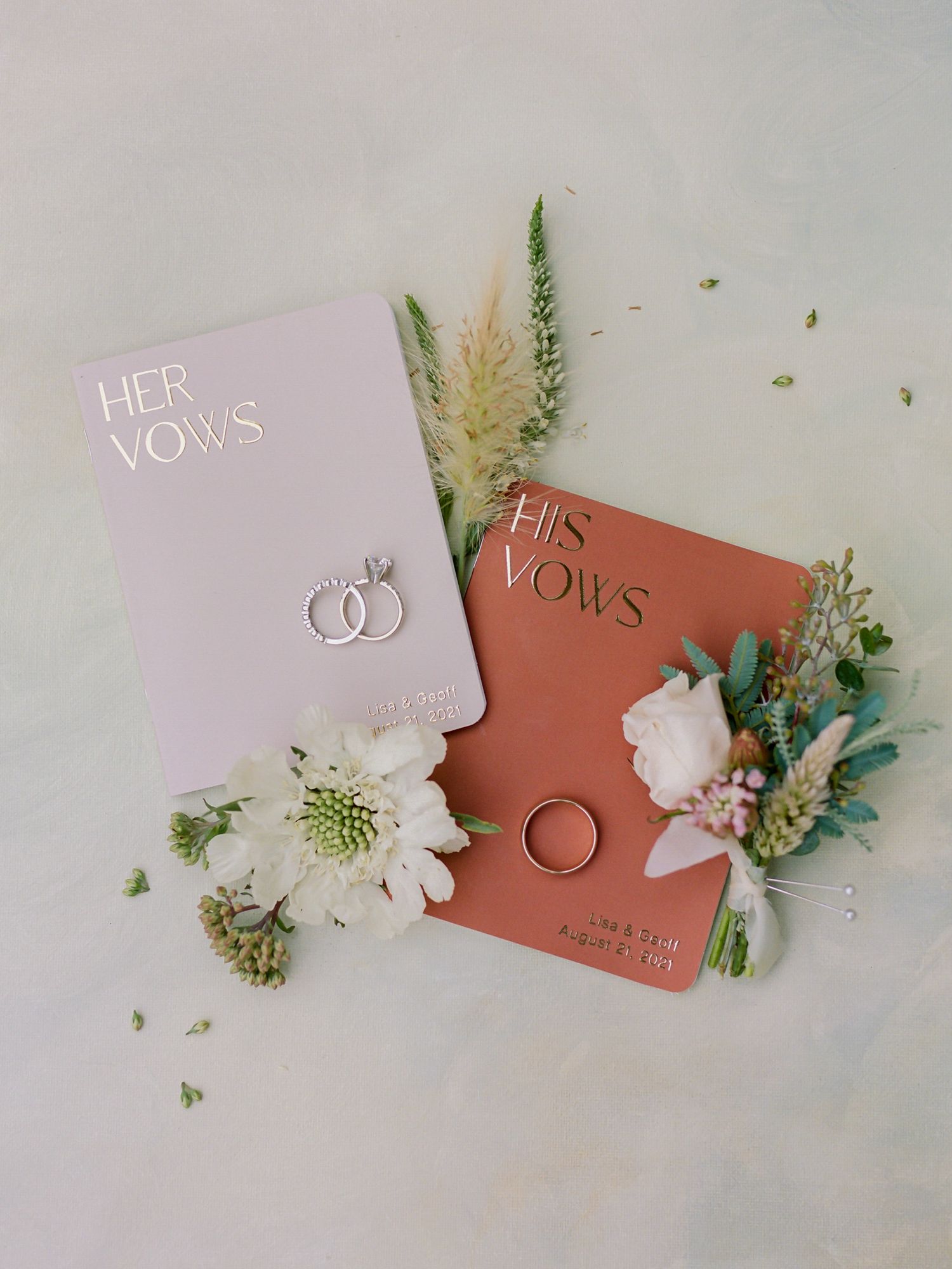His and her wedding vow books with floral decorations and wedding rings at Holman Ranch in Carmel Valley.