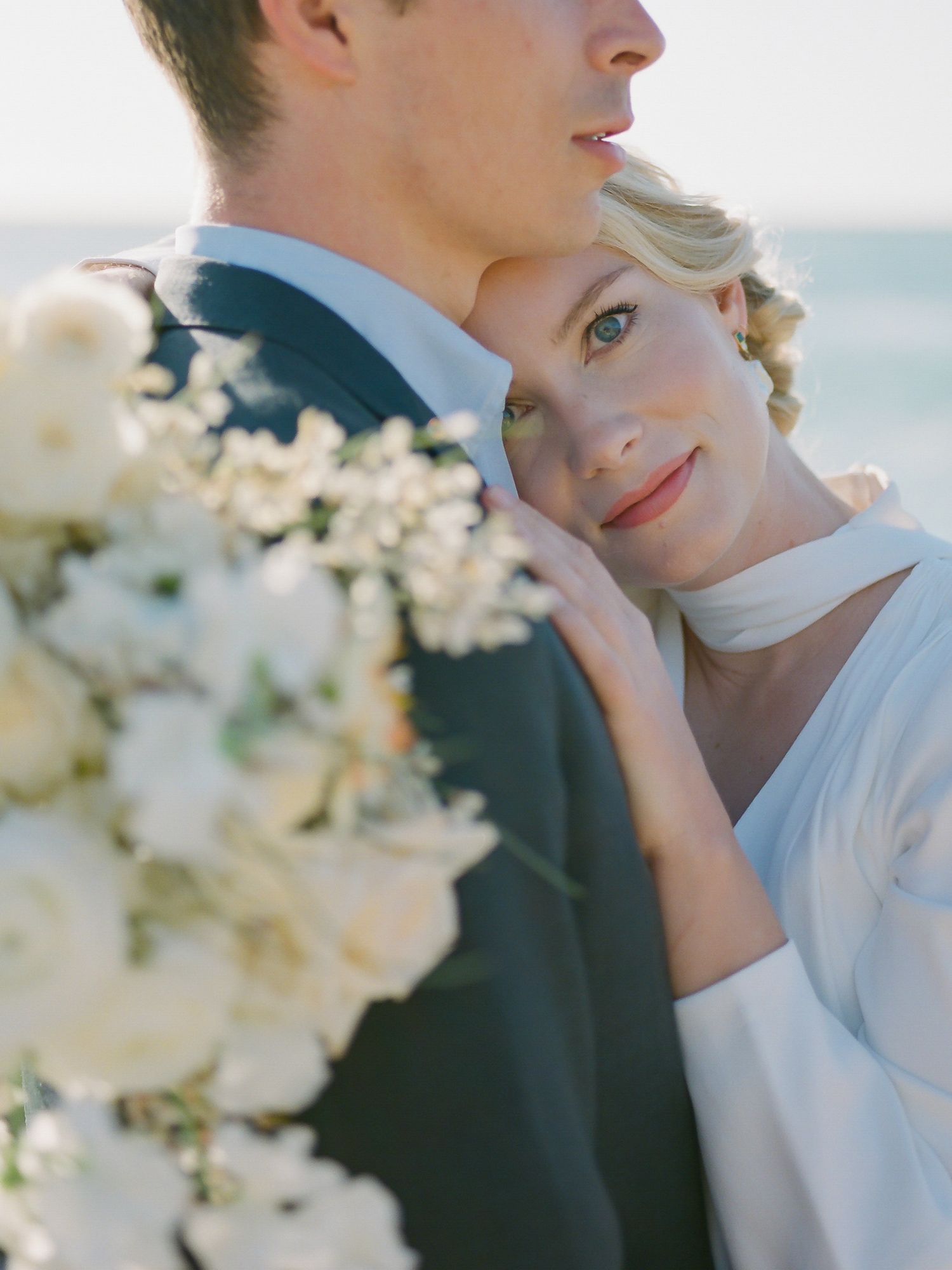 Intimate wedding portrait with white flowers and soft natural lighting in Carmel-by-the-Sea.