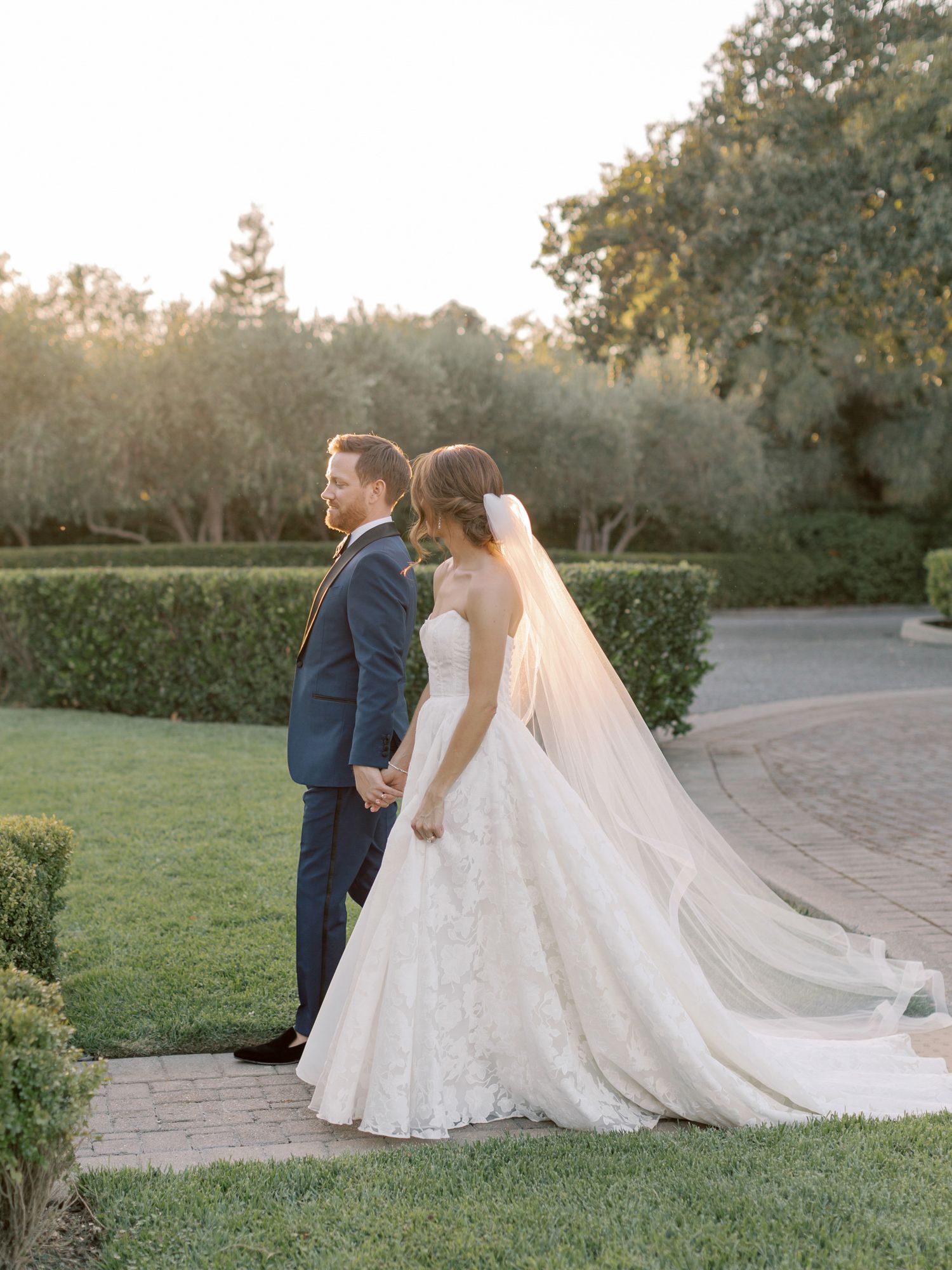 Bride and groom walking on a manicured garden path at The General's Daughter in Sonoma.