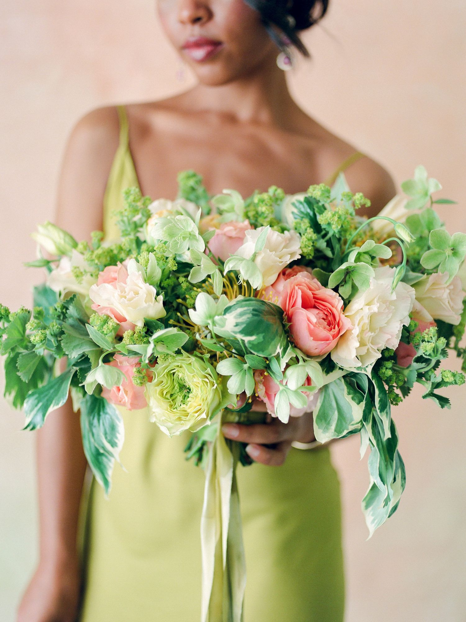 Bright spring bouquet with roses and greenery held against lime green dress in Napa.