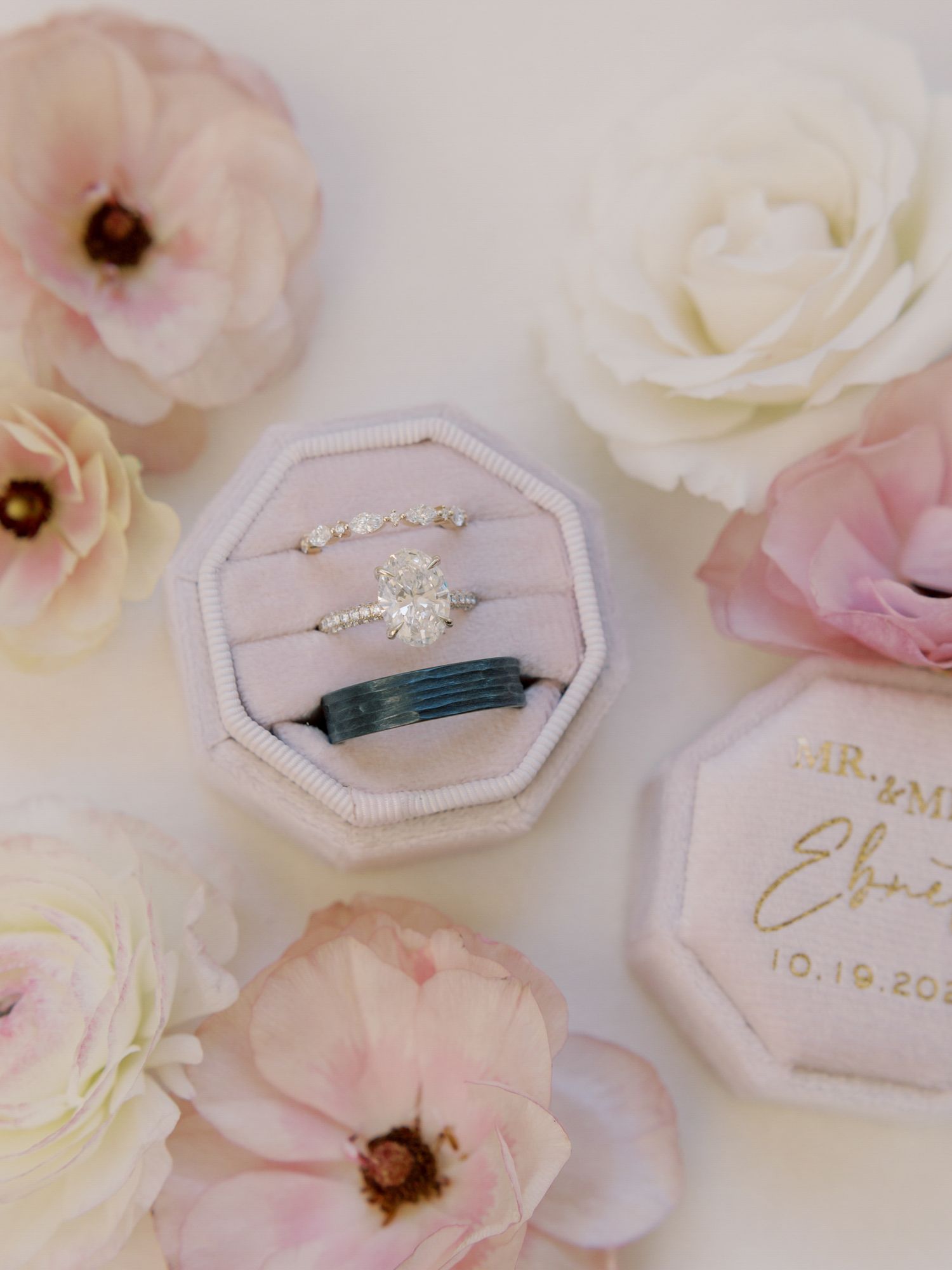 Wedding rings nestled in a pink velvet ring box surrounded by delicate pale roses and floral arrangements at Park Winters.