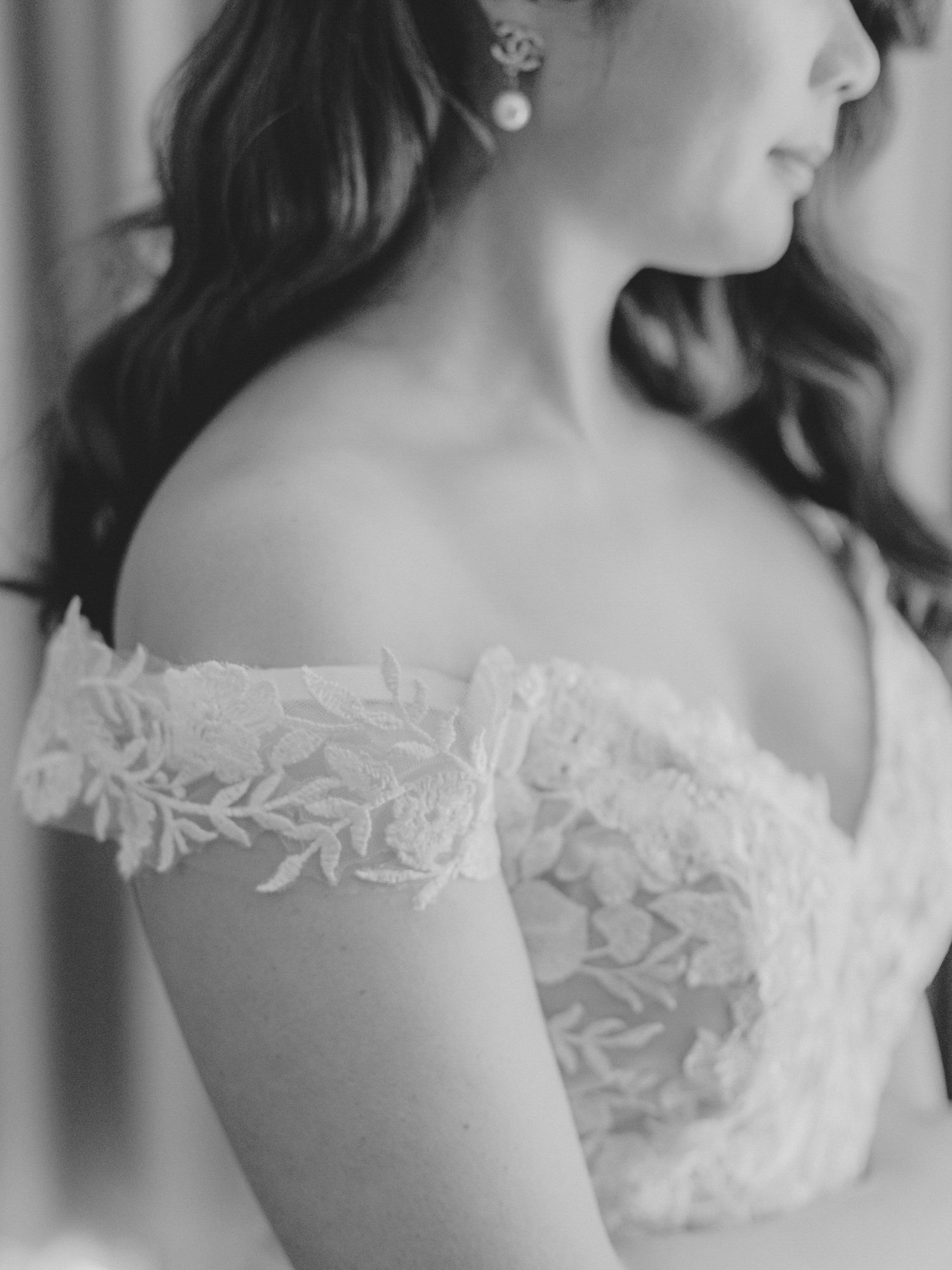 Close-up detail of a bride's lace off-the-shoulder wedding dress in black and white in Napa.