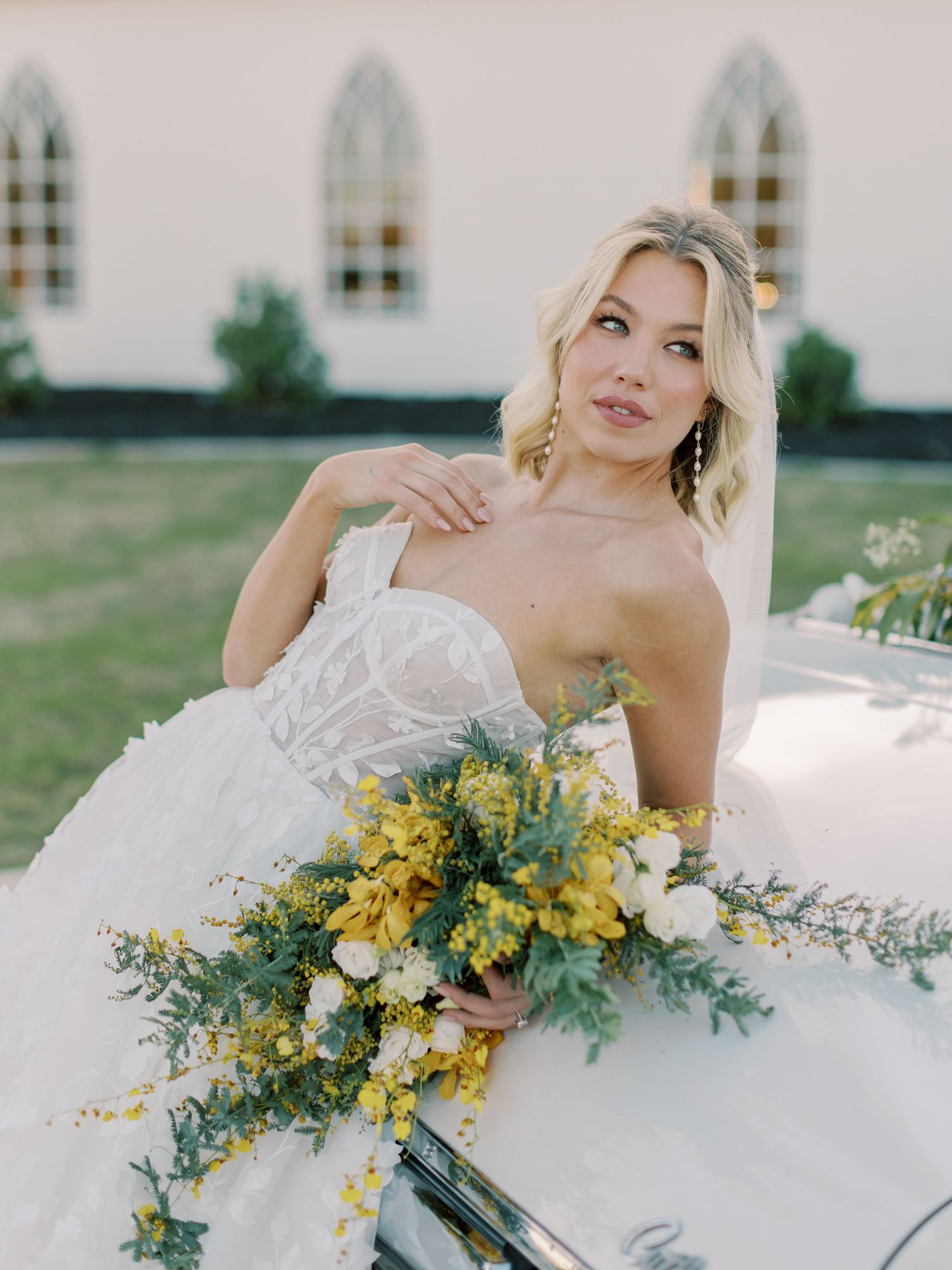 Bridal portrait with yellow and white wildflower bouquet against a church backdrop in Napa.