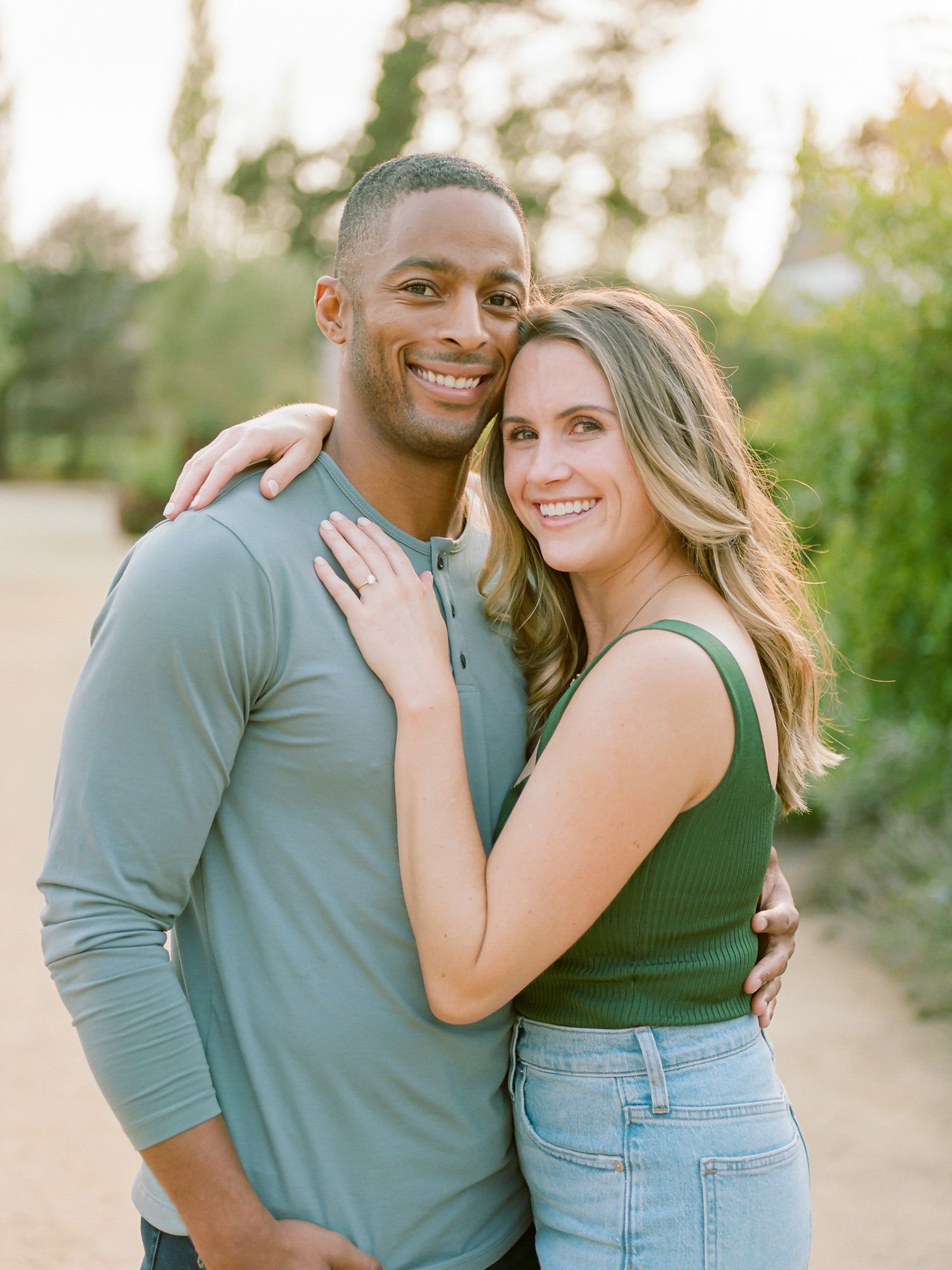 Happy engaged couple embrace outdoors during golden hour photoshoot at Cornerstone Sonoma.
