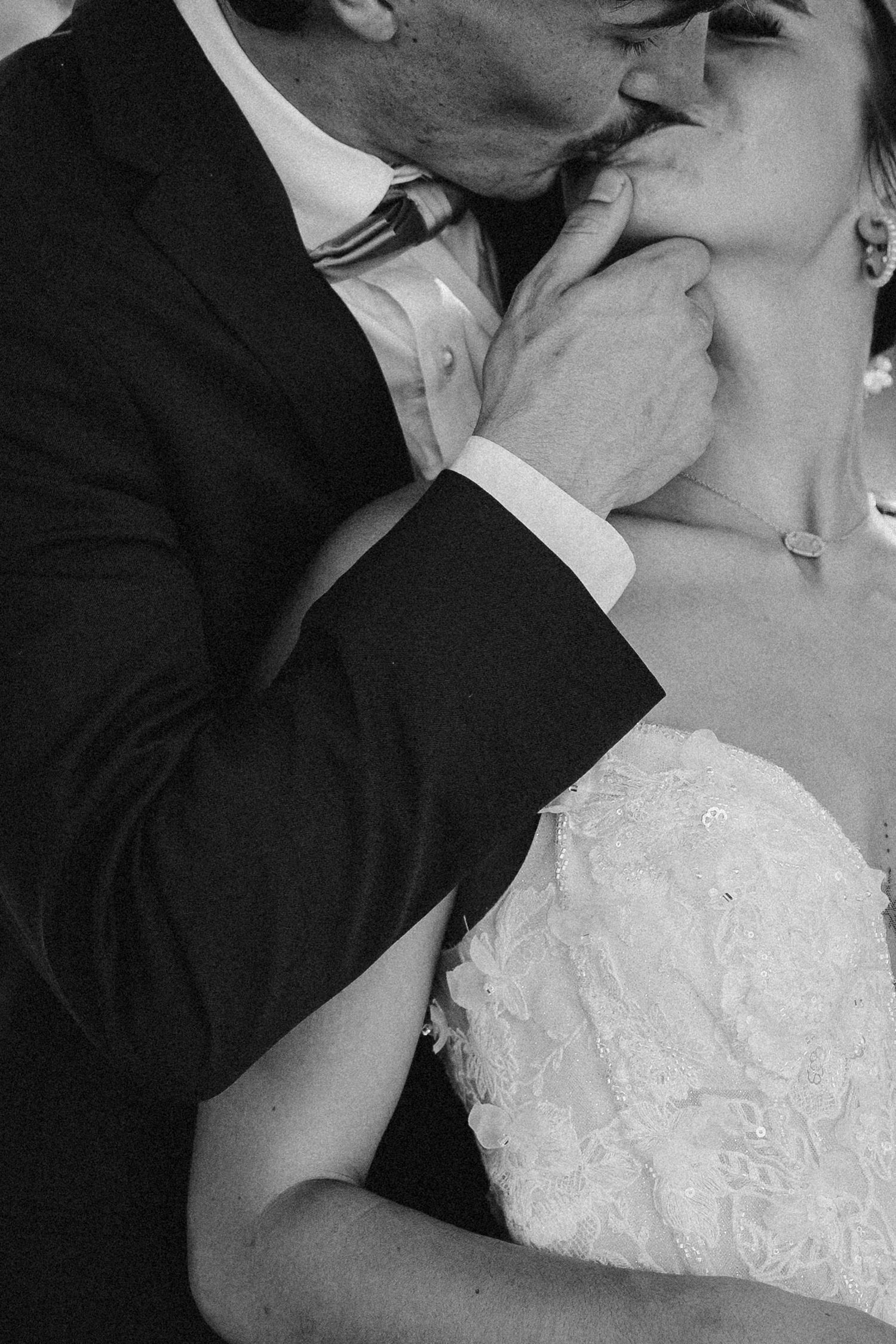 Black and white intimate portrait of newlyweds sharing tender moment.
