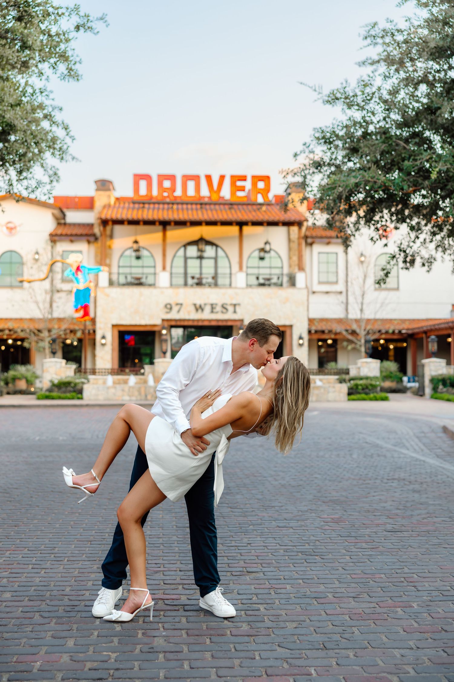 Romantic dance pose sequence showing a couple dipping in front of a vintage Denver storefront on brick pavement.