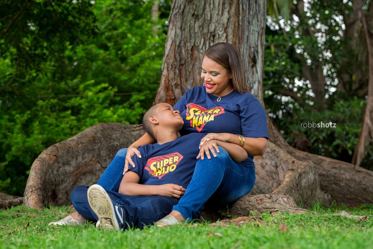 Couple's outdoor photo session showing intimate moments near a tree trunk.