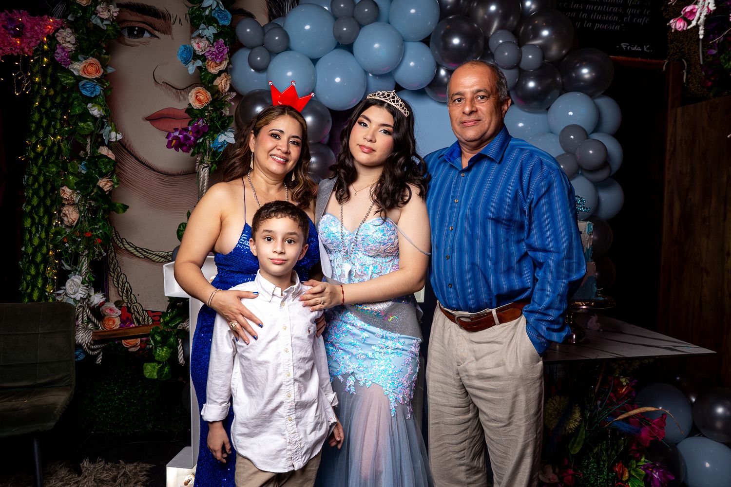 People celebrating at a party with balloons and decorations in a festive indoor setting.