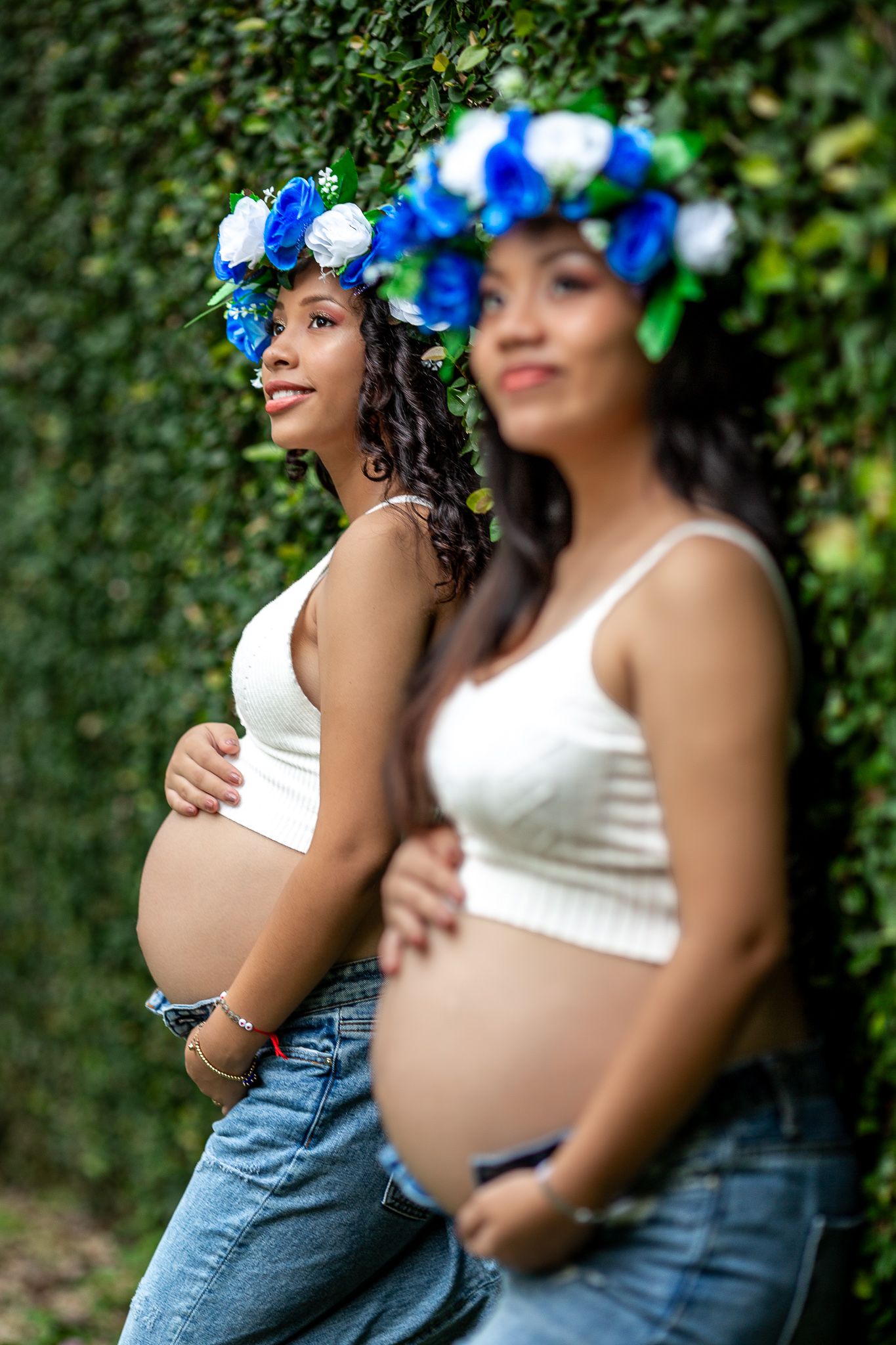 Double exposure style maternity photo with two poses against ivy wall.