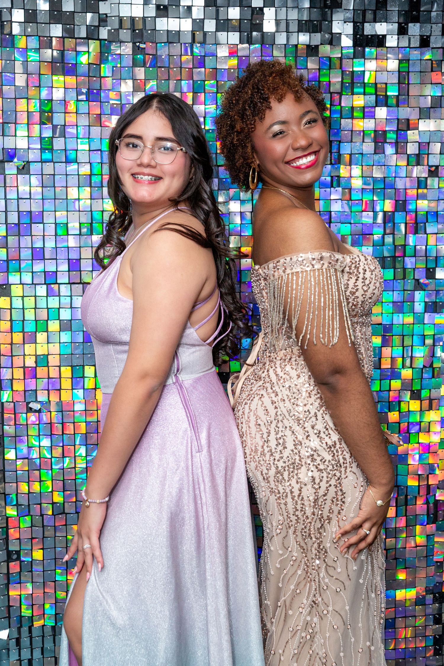 Group of friends posing together against a colorful mosaic tile wall backdrop at a celebration event. graduation party