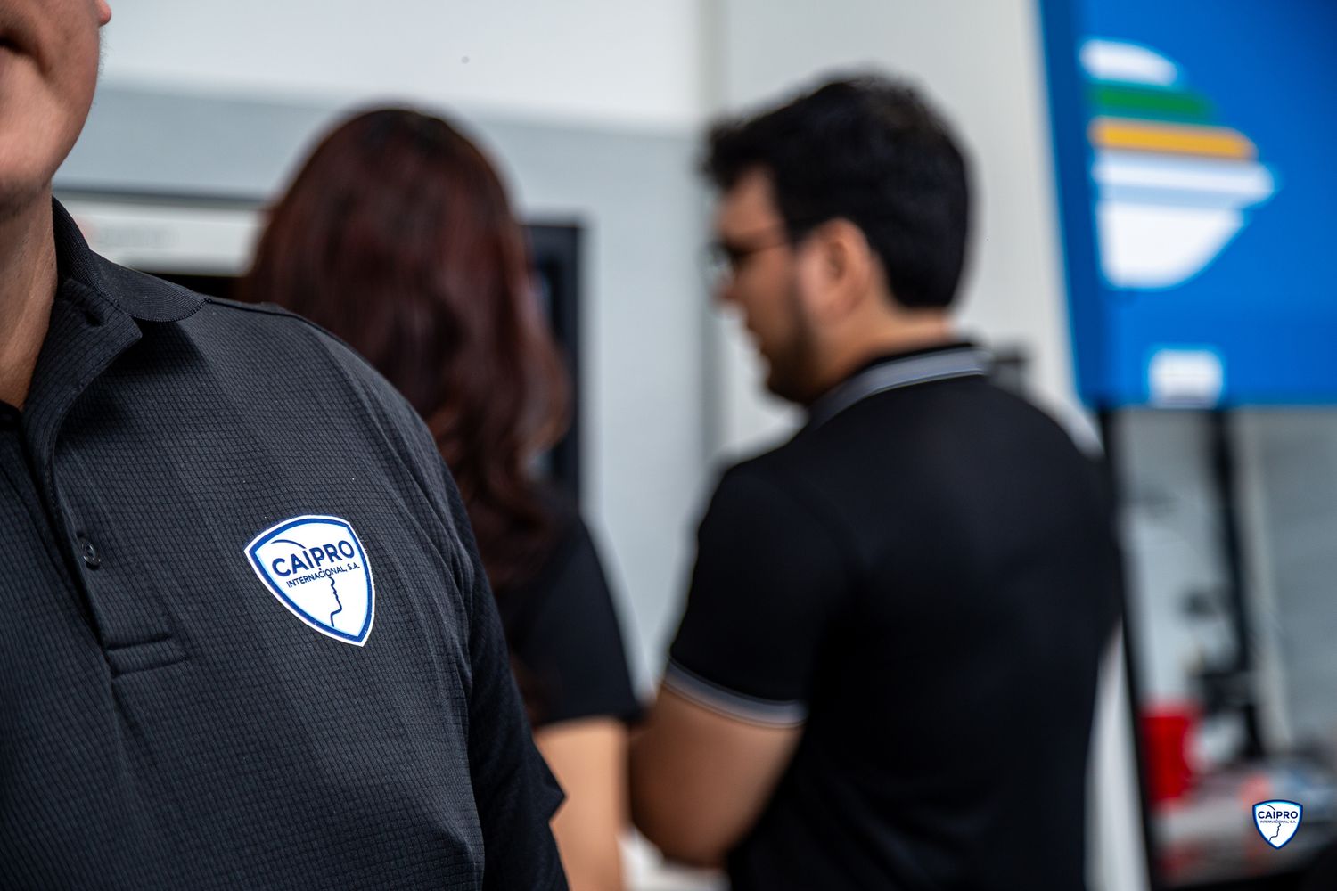 The image shows two people in police uniforms standing together in an indoor setting.