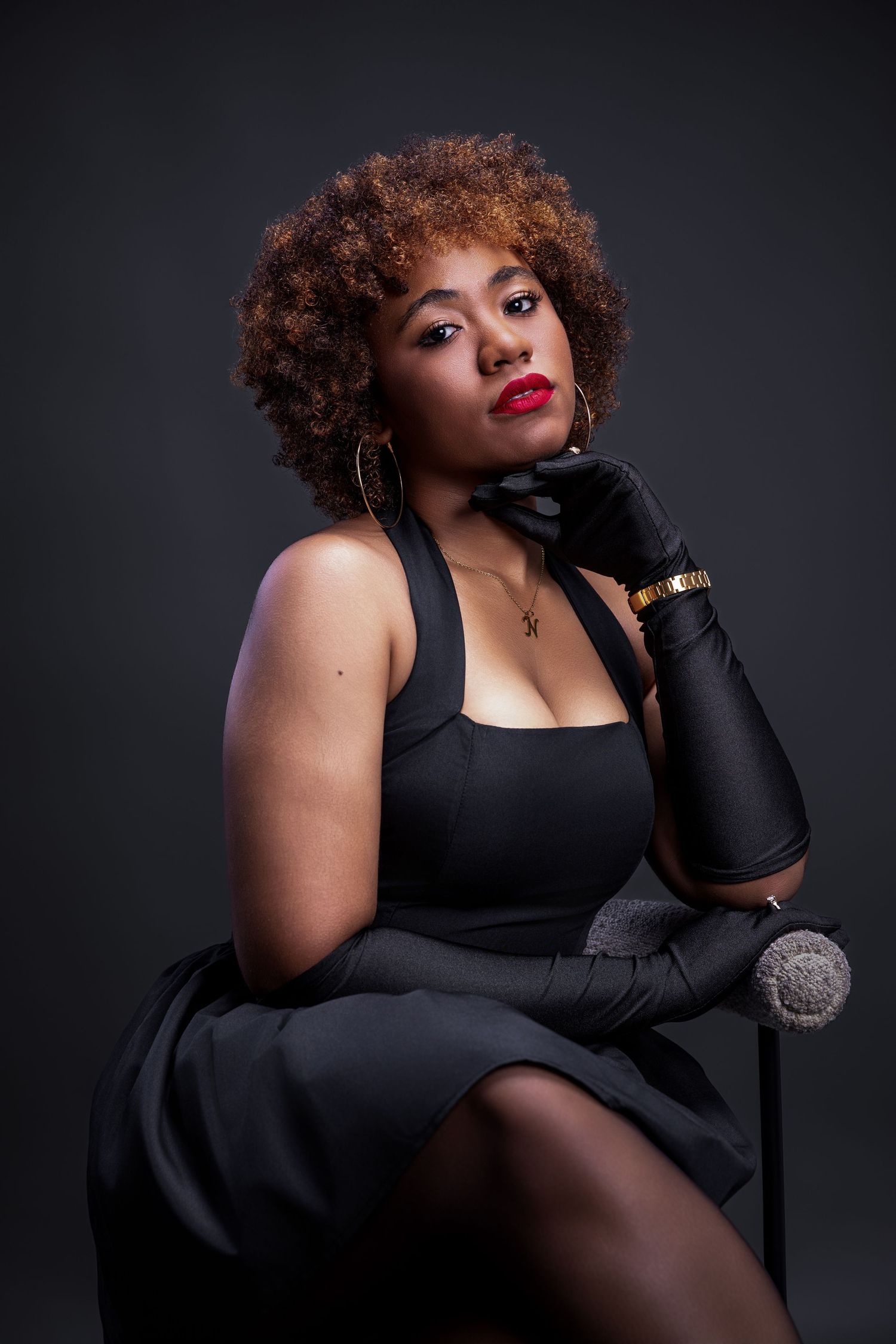 Dramatic fashion portrait series featuring a model in black dress and gloves posing against dark background.