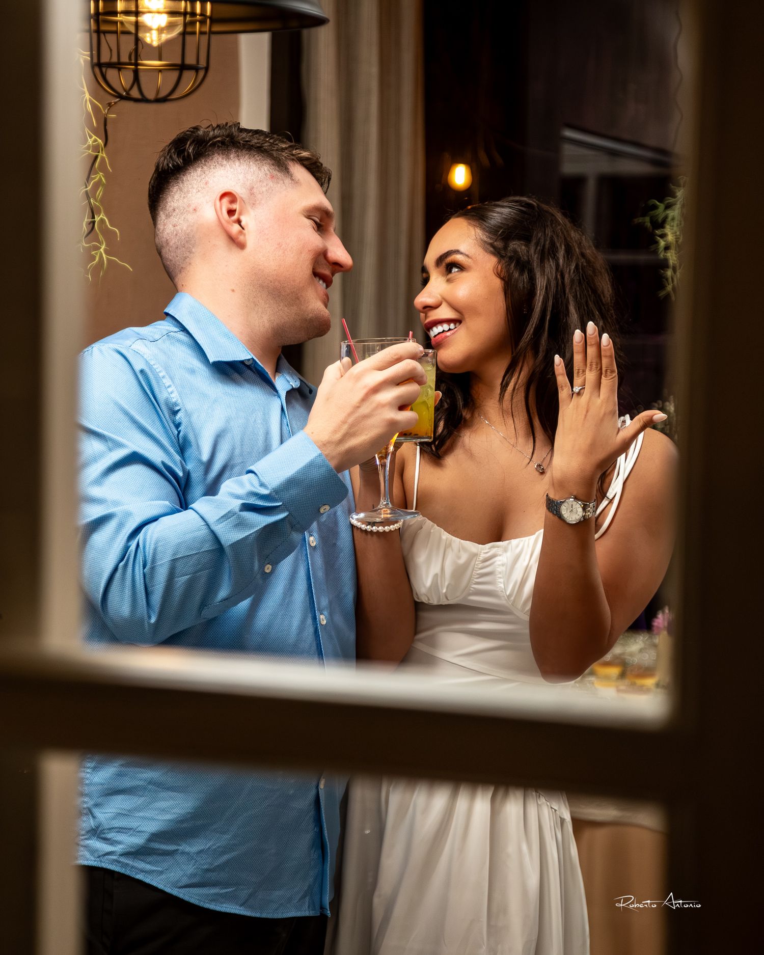 A couple shares intimate moments while dining at a romantic restaurant with warm lighting and elegant decor. Marriage proposal photo