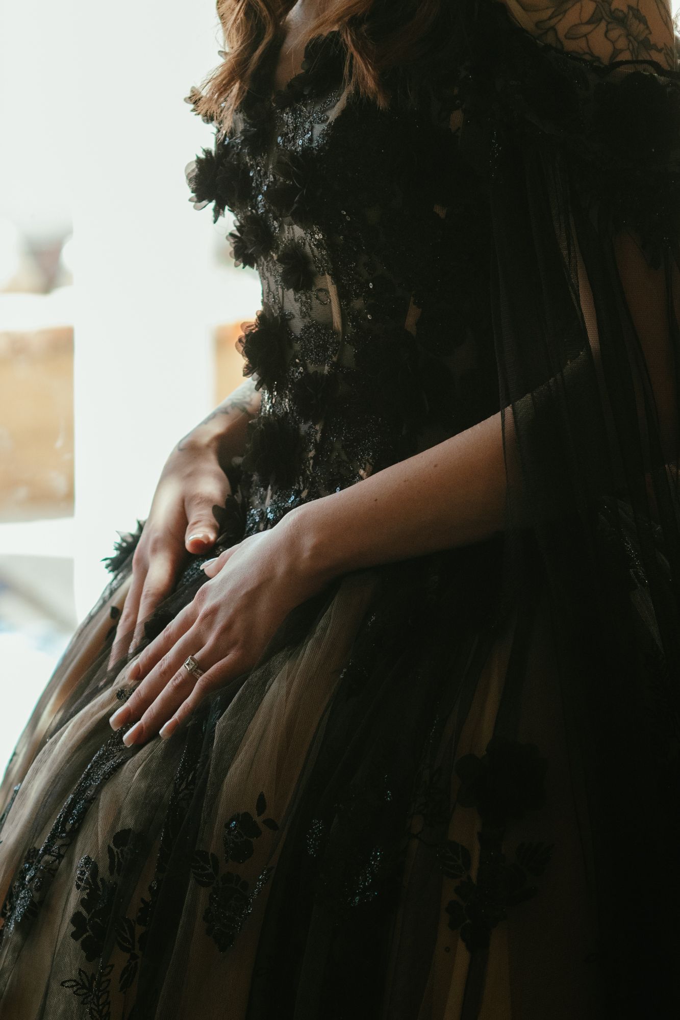 Close-up of bride in stunning black lace and tulle wedding gown with floral details.