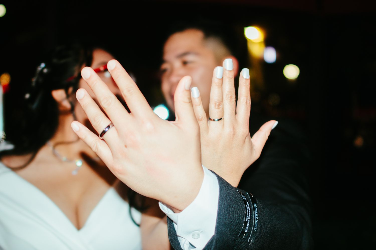 Newlyweds showing off their wedding rings at their wedding reception celebration.