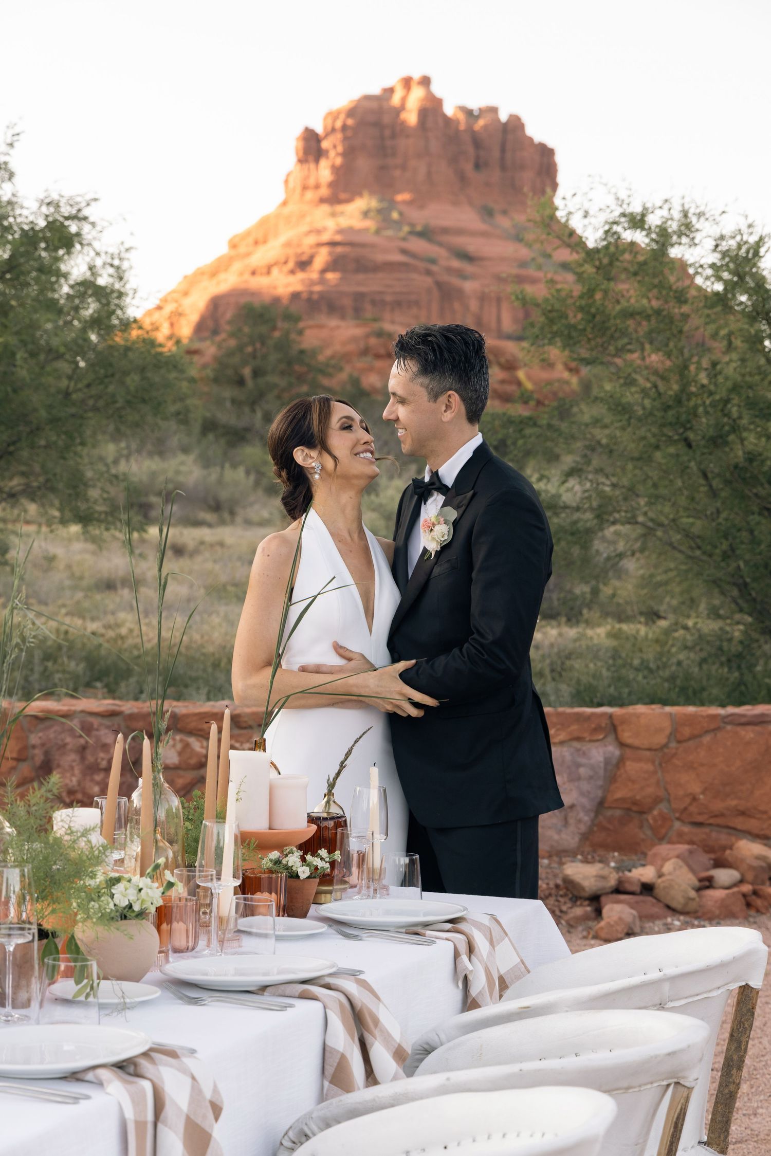 Newlyweds share a romantic moment at Red Agave Resort with red rocks formation in Sedona as backdrop.