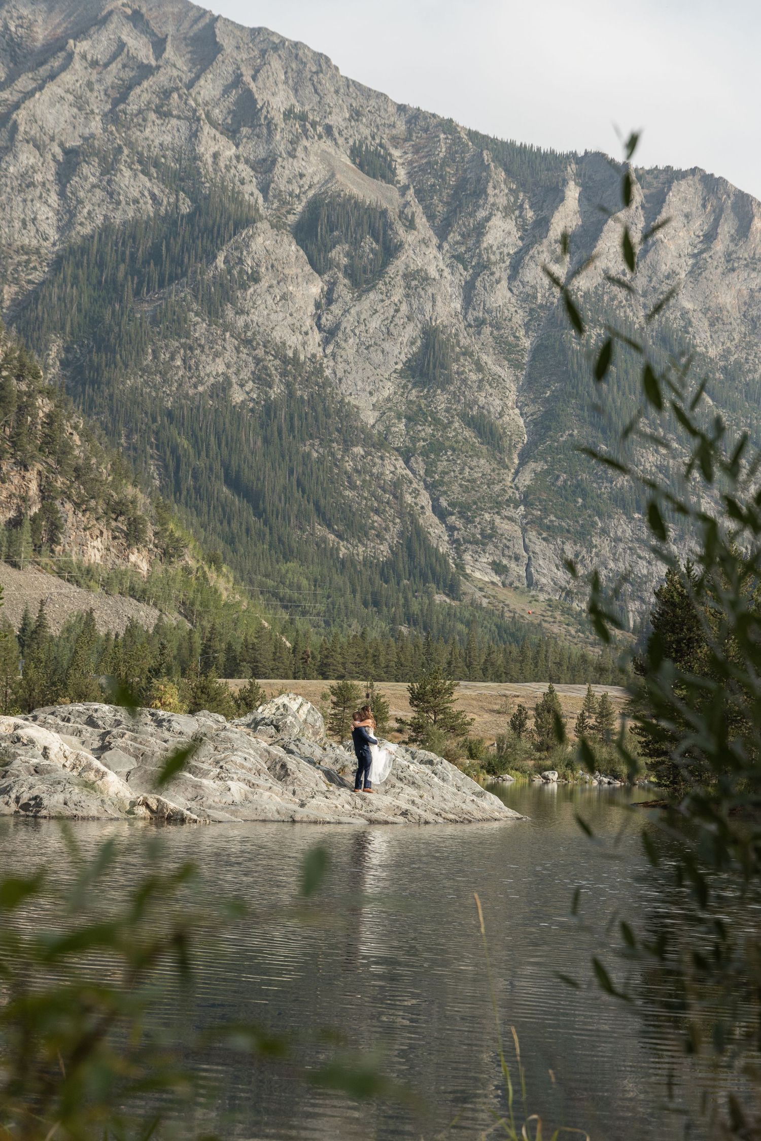 A scenic mountain lake surrounded by rugged peaks and evergreen trees in a remote wilderness setting.