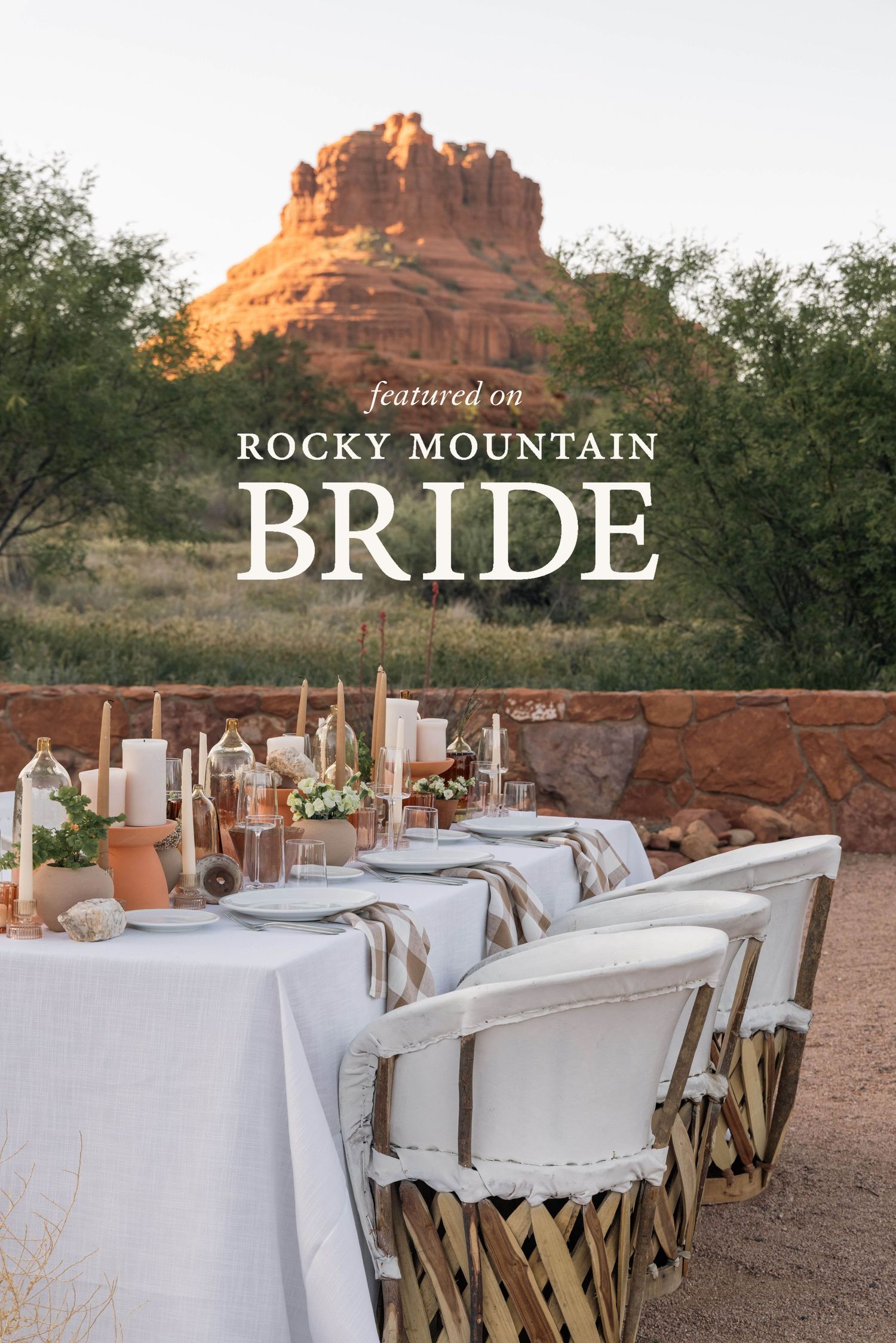 Elegant outdoor wedding table setup with white tablecloth and chairs against dramatic Bell Rock formation in Sedona, Arizona.