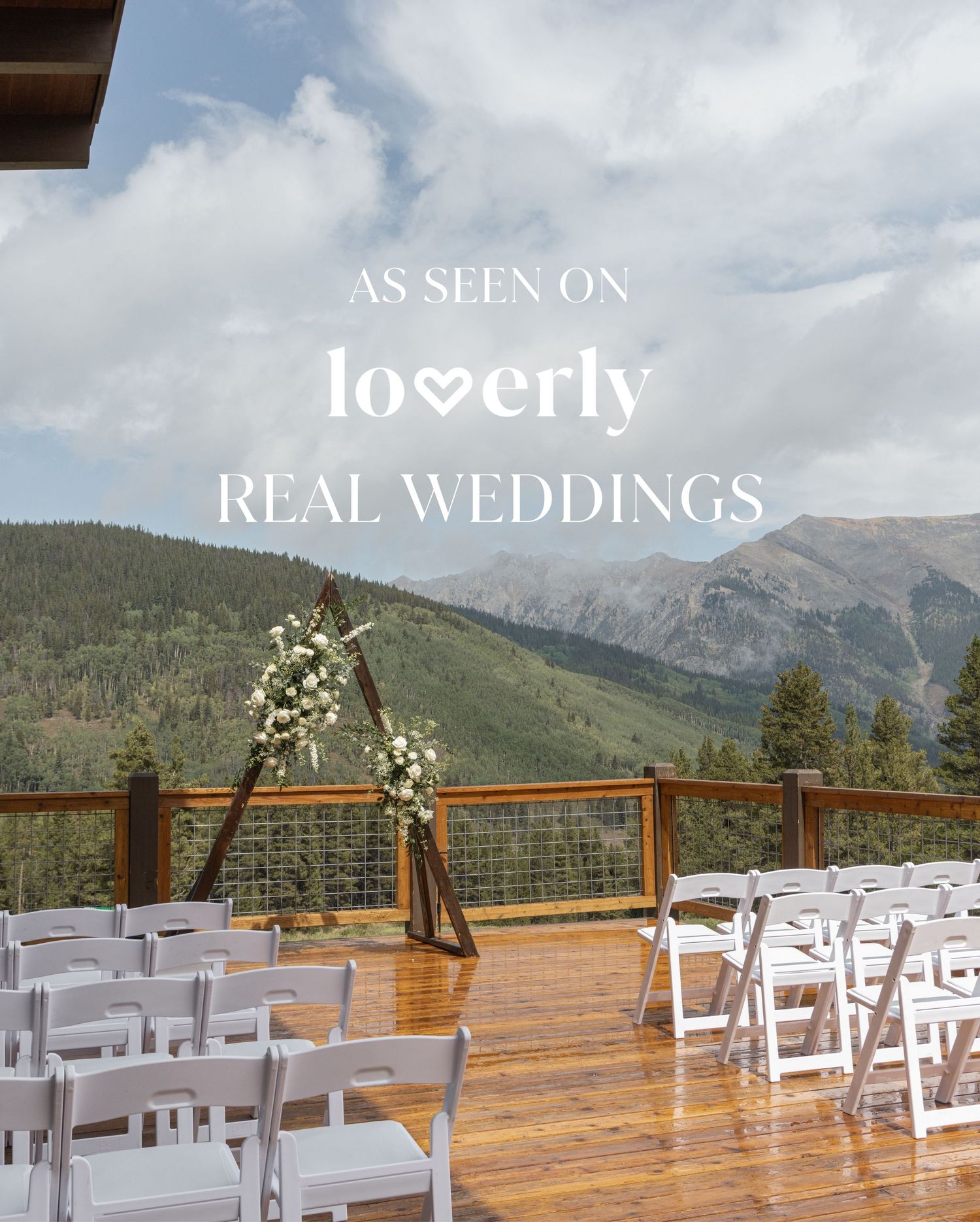 Outdoor mountain wedding ceremony setup with white chairs and floral arch on wooden deck, featured on Loverly Real Weddings.