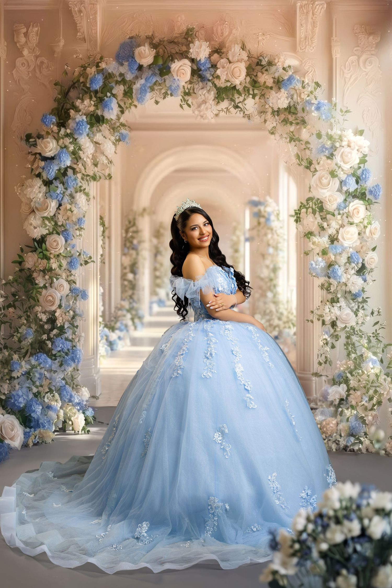 Young woman in a light blue ball gown with floral appliques poses under a floral arch in an elegant hall.